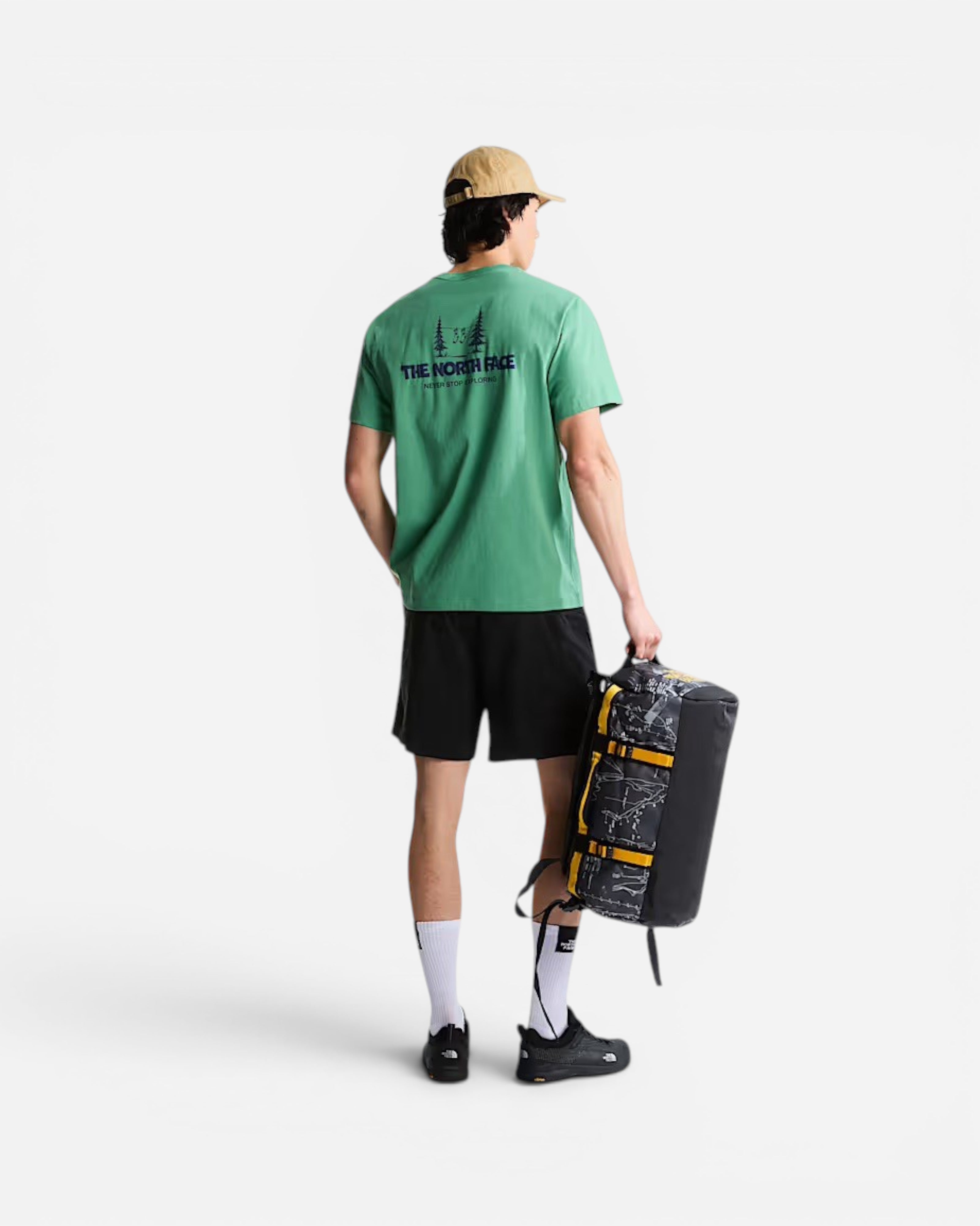Astrofat model carrying a 31L Base Camp duffel bag in anthracite grey with a topographic print and summit gold accents.