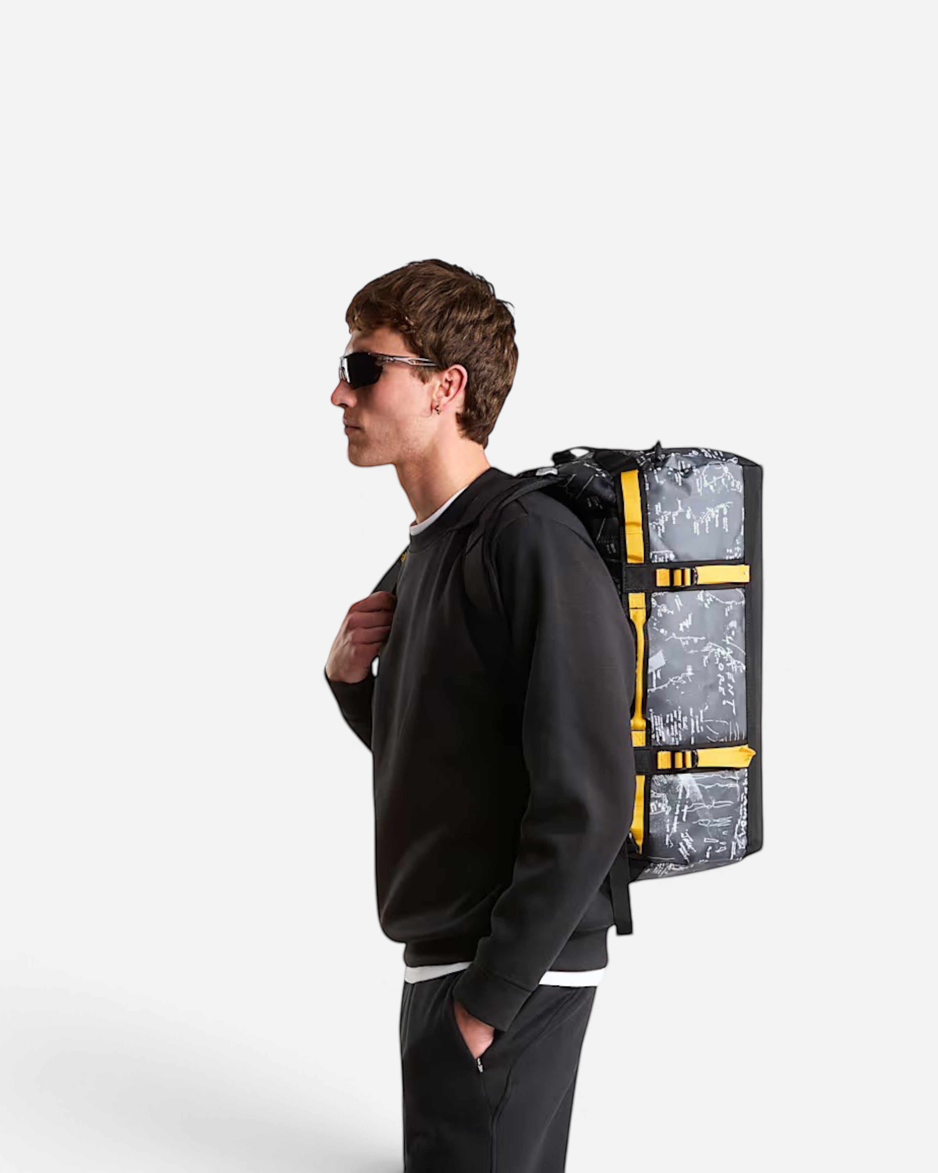 Astrofat Base Camp Duffel 50L in anthracite grey topos print with summit gold straps worn as a backpack by a man.