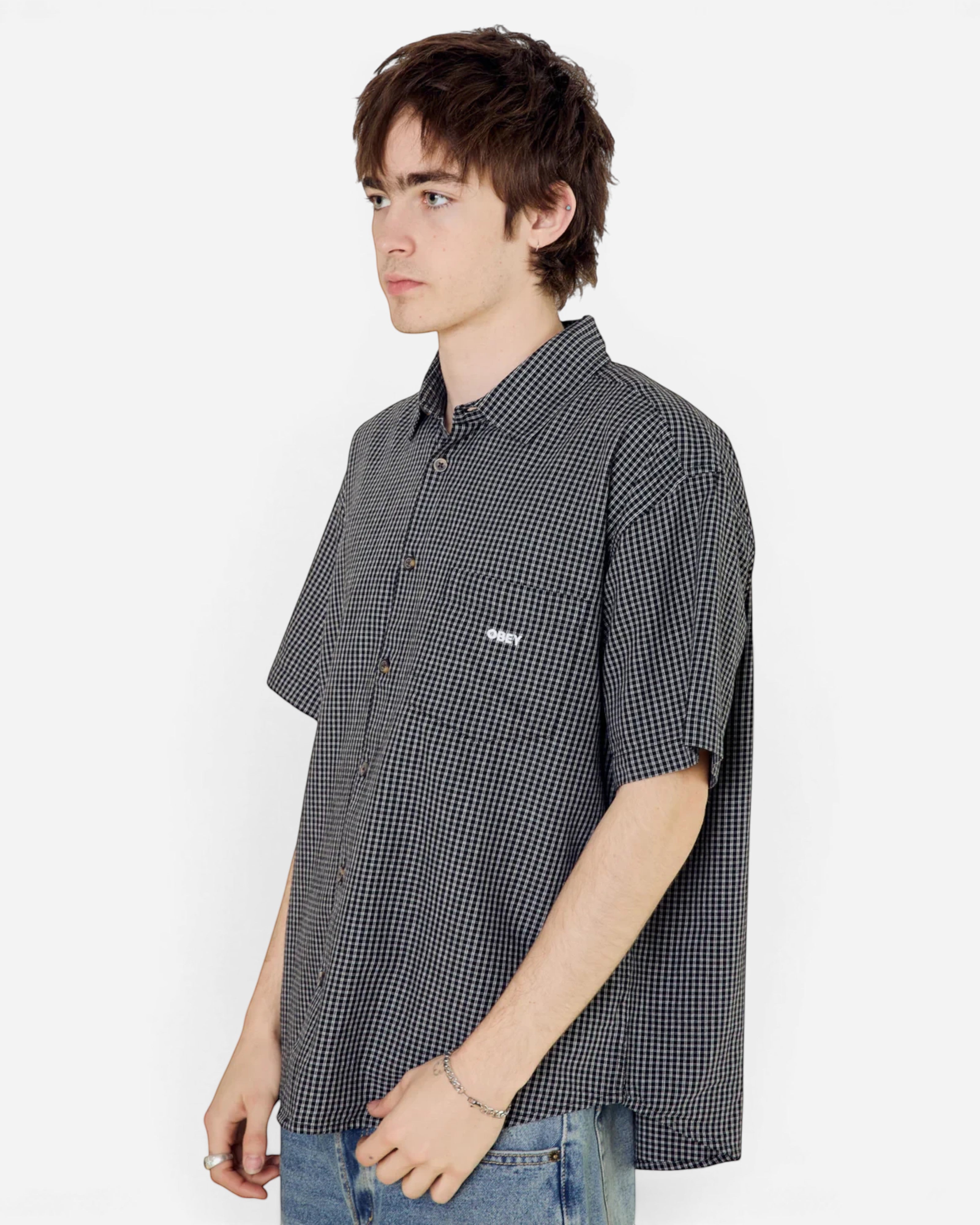 Astrofat Bigwig black and white gingham short sleeve shirt with a chest pocket and logo, worn by a male model.