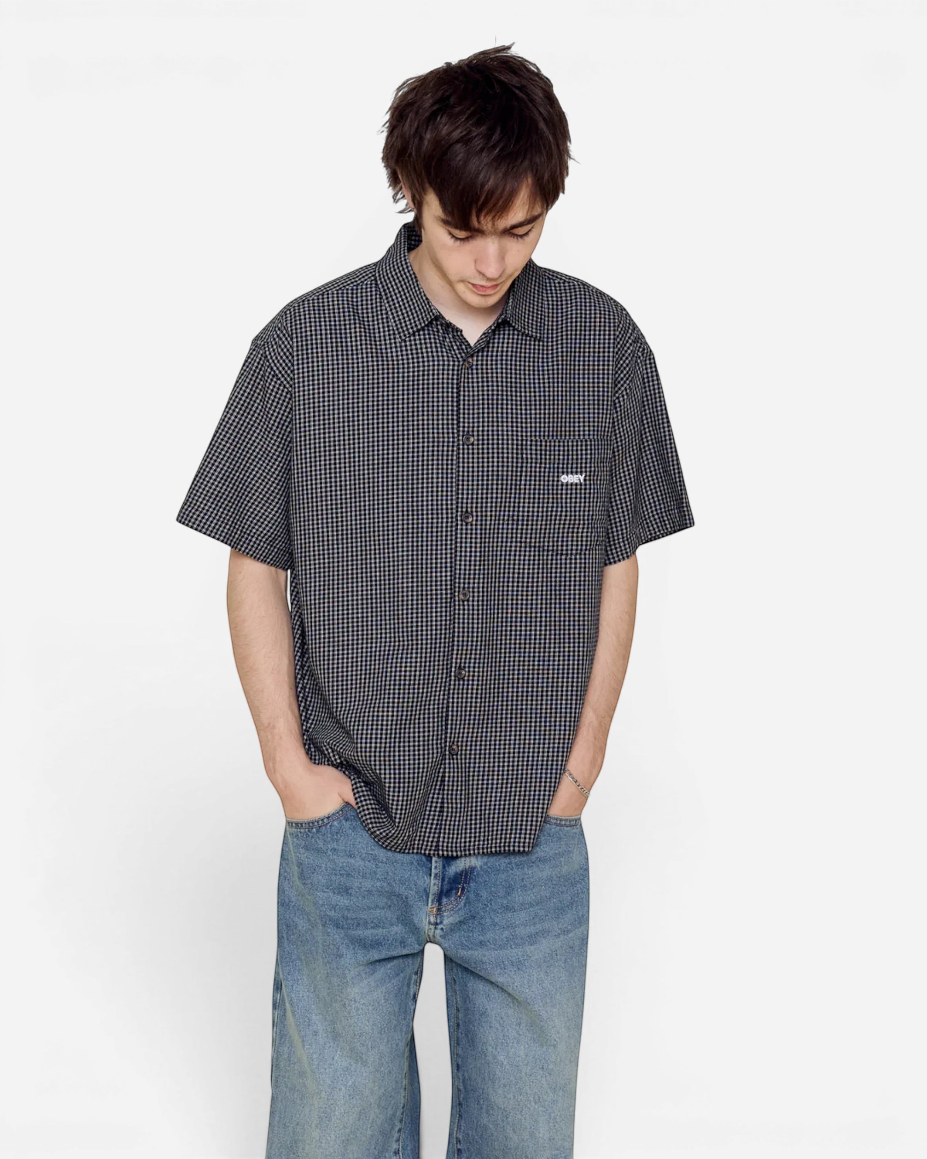 Astrofat Bigwig Frank short sleeve black gingham shirt with a chest pocket and logo, worn by a man with blue jeans.