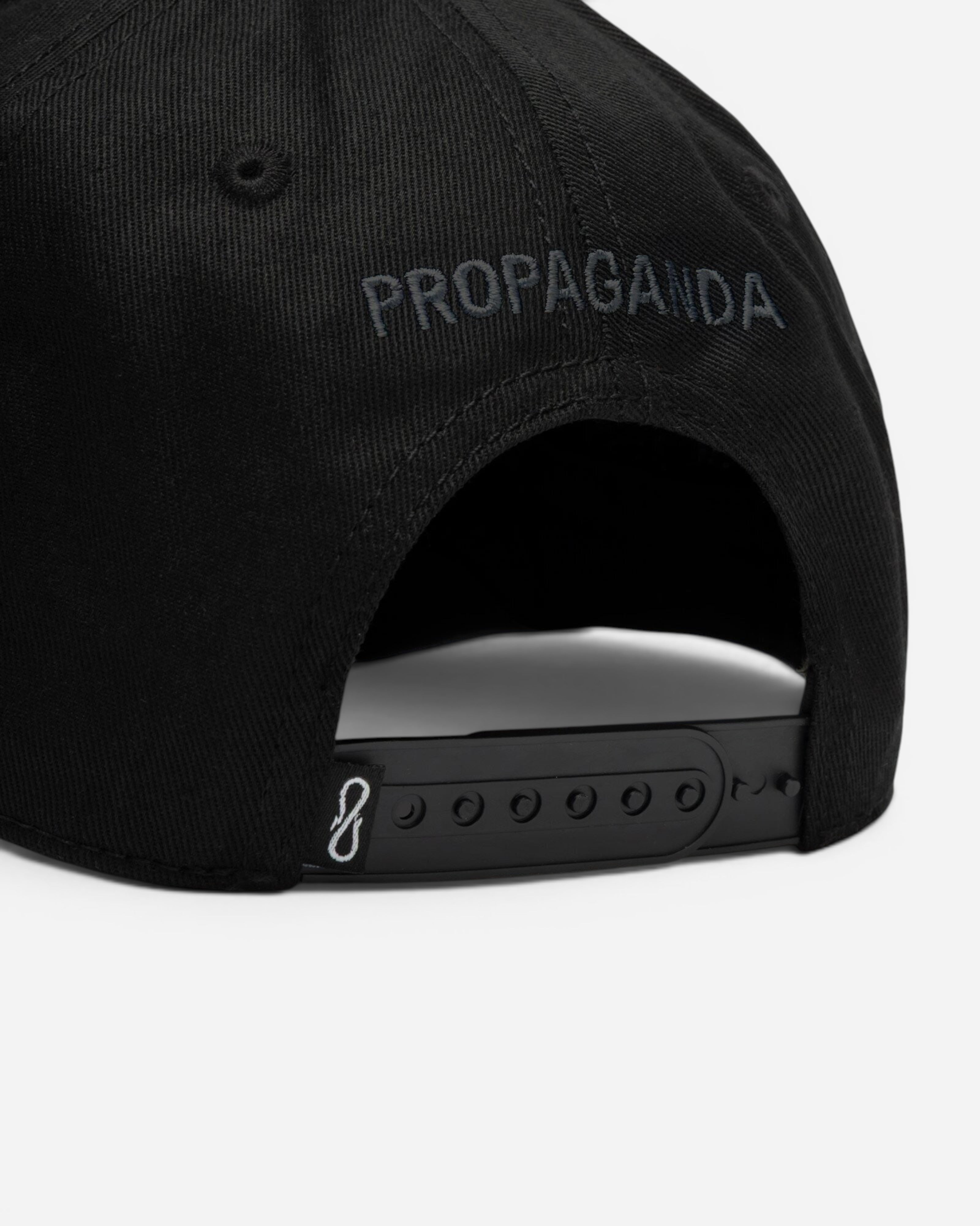Astrofat black cotton snapback hat with Propaganda logo embroidery on the back and adjustable plastic strap closure.