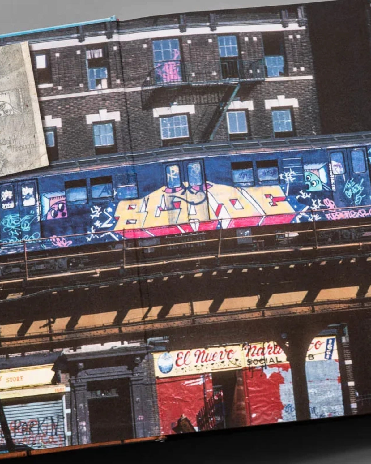 Astrofat BLADE King Of Graffiti hardcover book open to a page showing a vintage NYC subway train with graffiti art