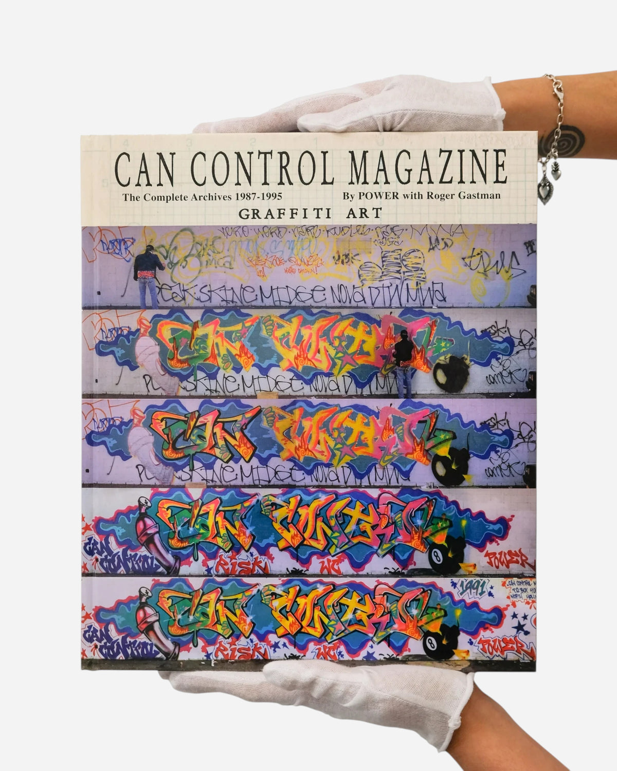 Astrofat Can Control Magazine hardcover book featuring graffiti art archives held by hands in white archival gloves.