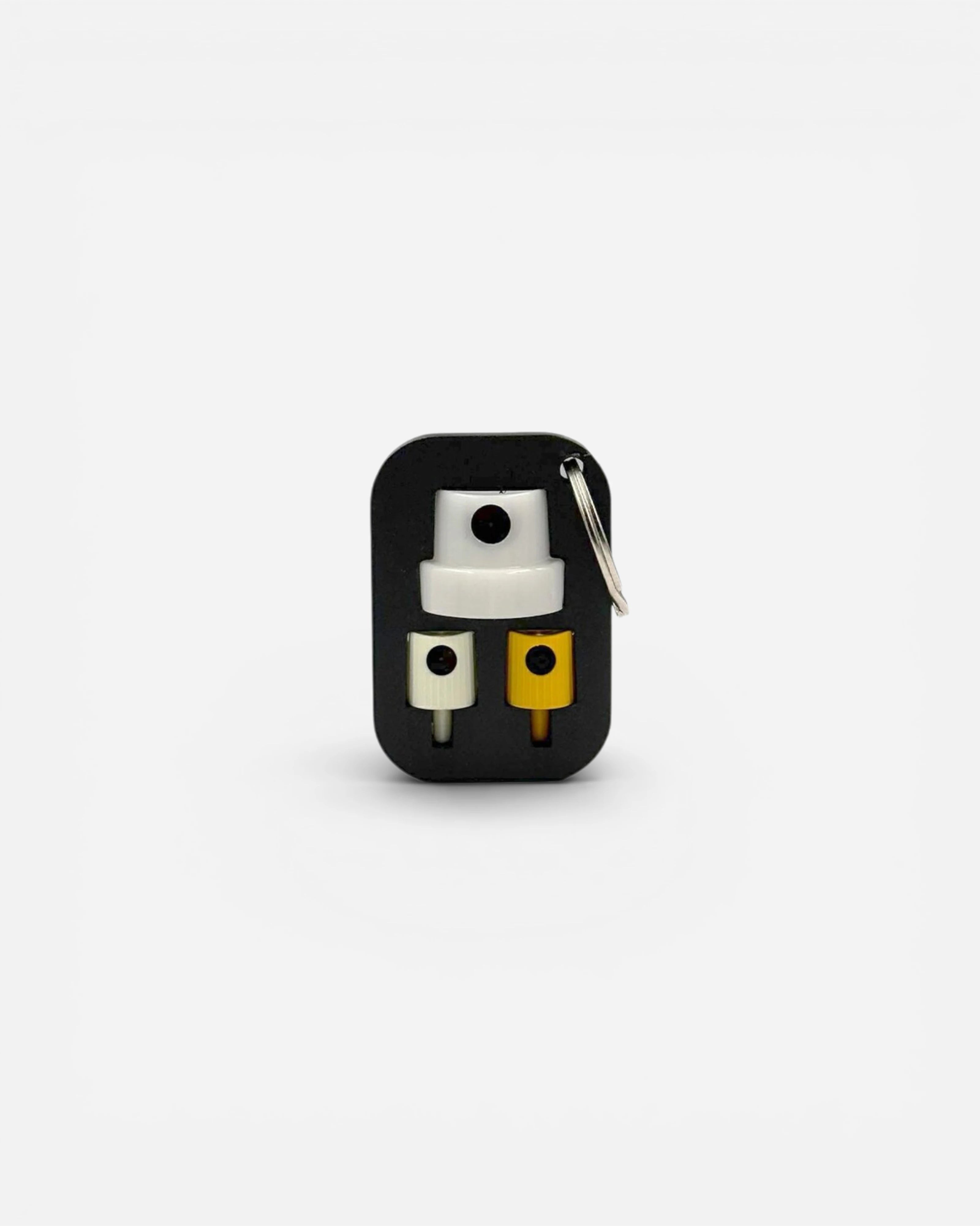 keychain holding three spray paint caps: one white, one cream, and one yellow. Features a keyring for attachment.
