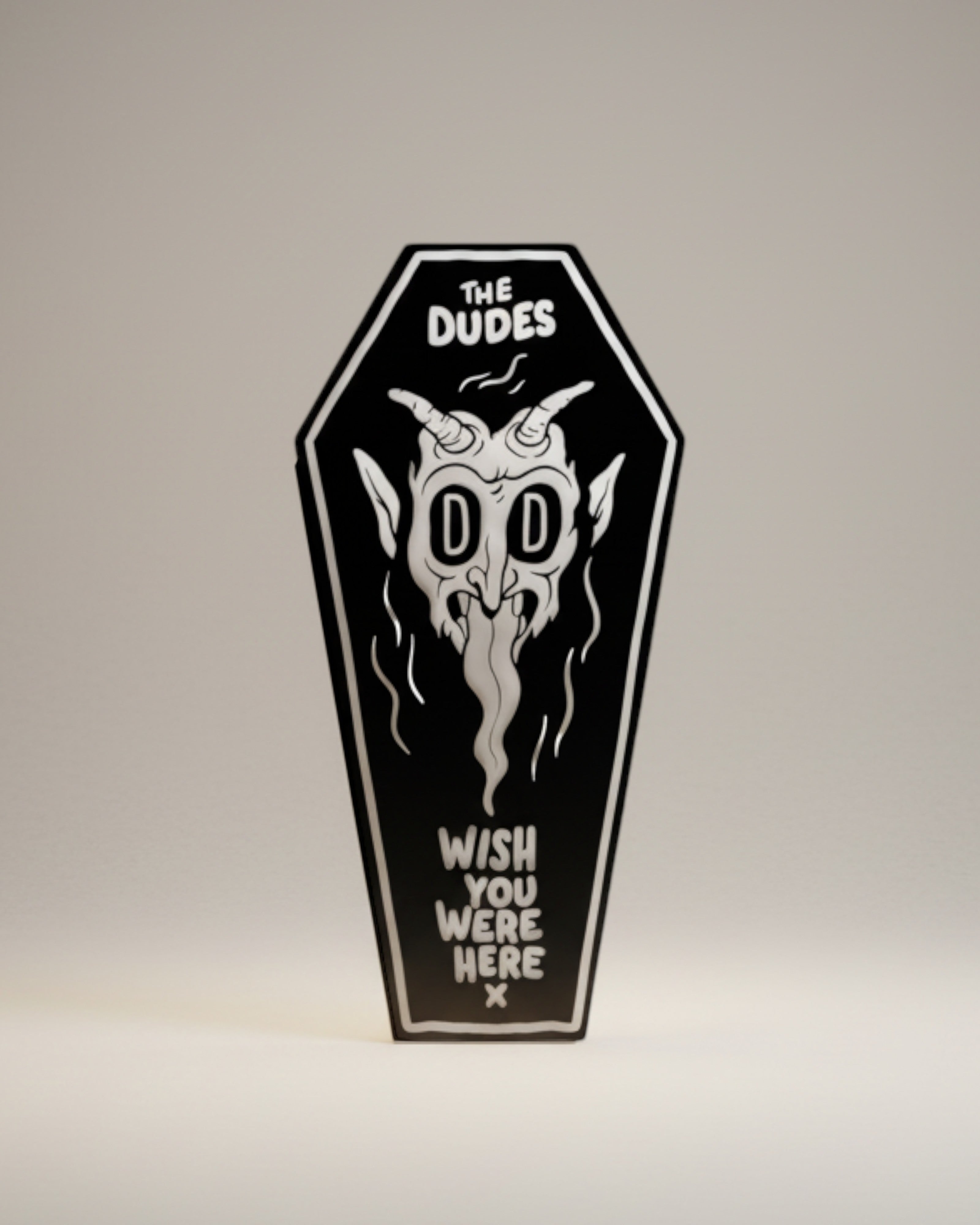 Astrofat The Dudes coffin-shaped beach towel in black with white devil graphic and text.