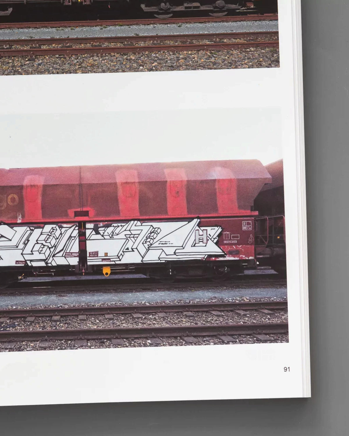 Astrofat book page showing a red-brown DB freight train car painted with white and black graffiti by Boris DELTA