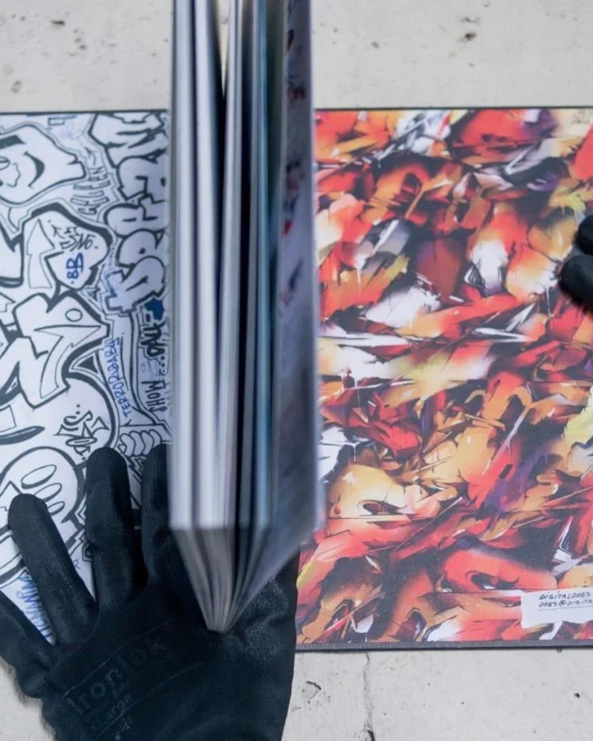 Astrofat DOES First 20 Years book open to show graffiti sketches and vibrant abstract artwork on concrete background