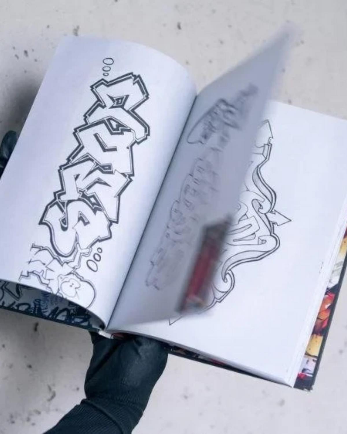 Astrofat DOES First 20 Years book showing graffiti sketches and handwritten notes on open pages