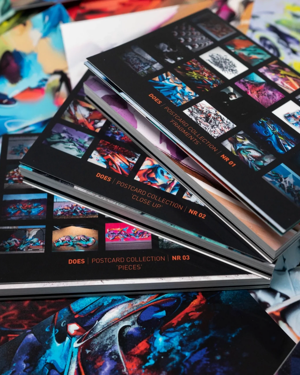Astrofat DOES limited edition postcard set featuring three booklets of vibrant graffiti art prints on a colorful background