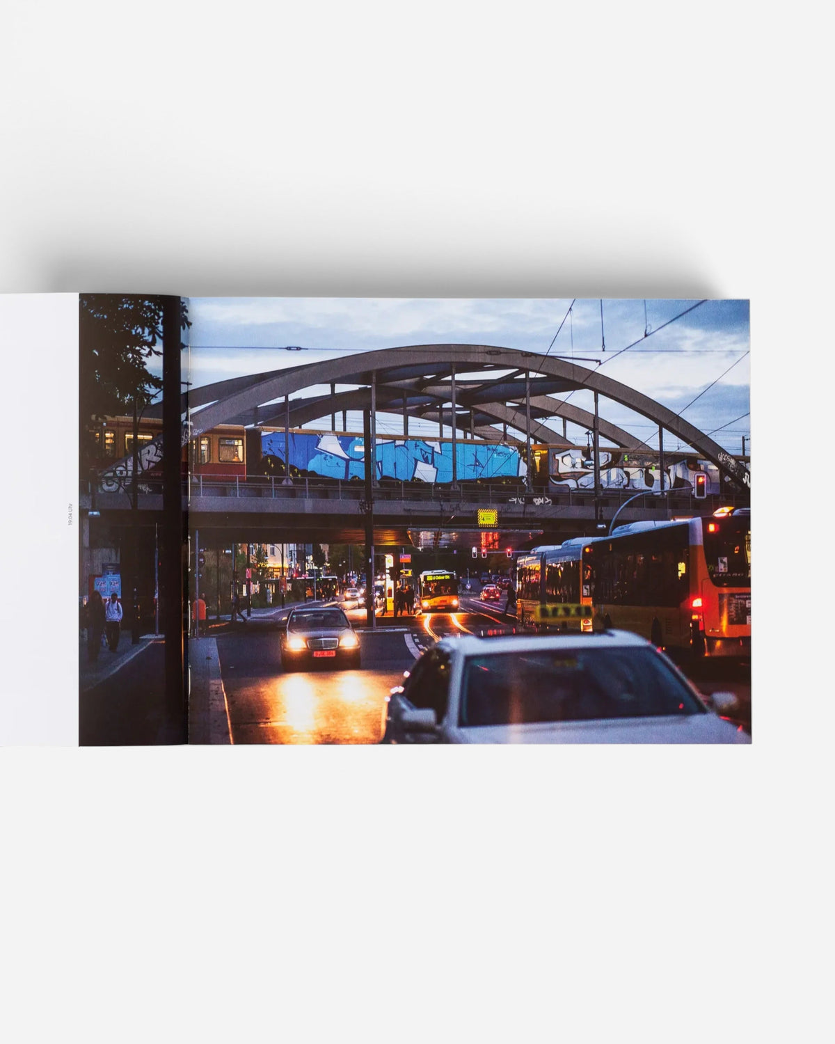 Astrofat Farbzüge photography book spread showing a graffiti-covered train crossing a Berlin bridge at dusk