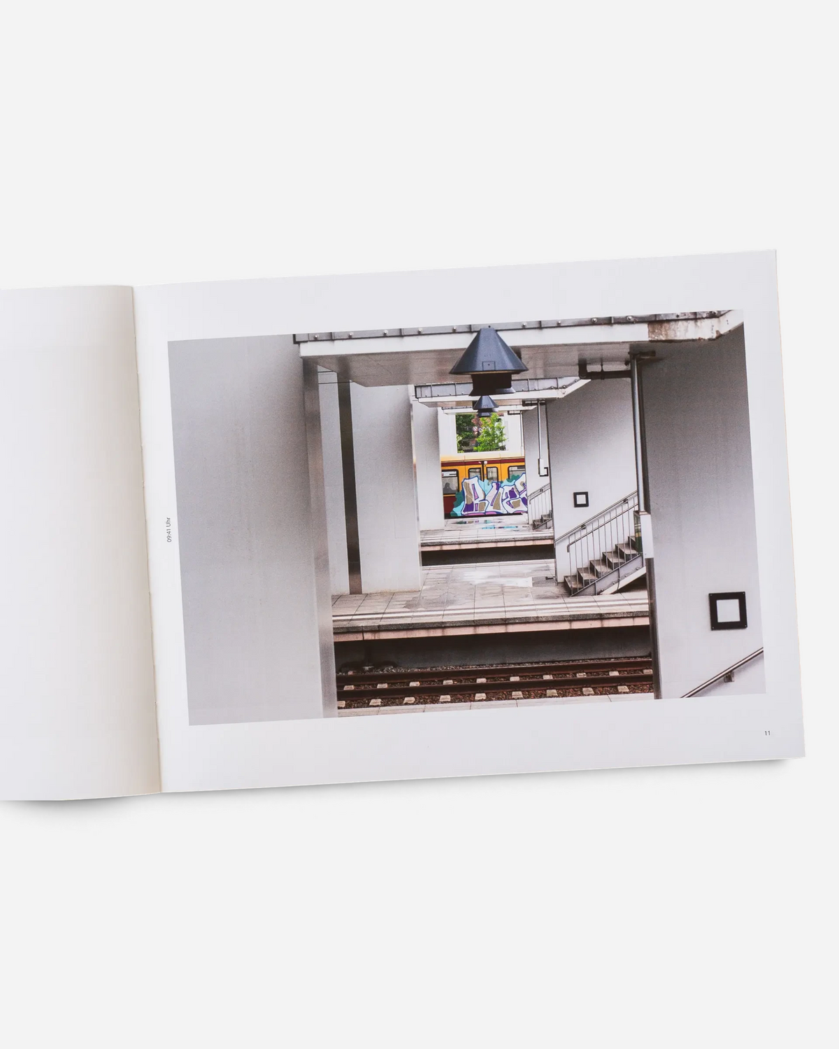 A page from the Astrofat Farbzüge photography book showing a graffiti-covered train through a Berlin station archway.