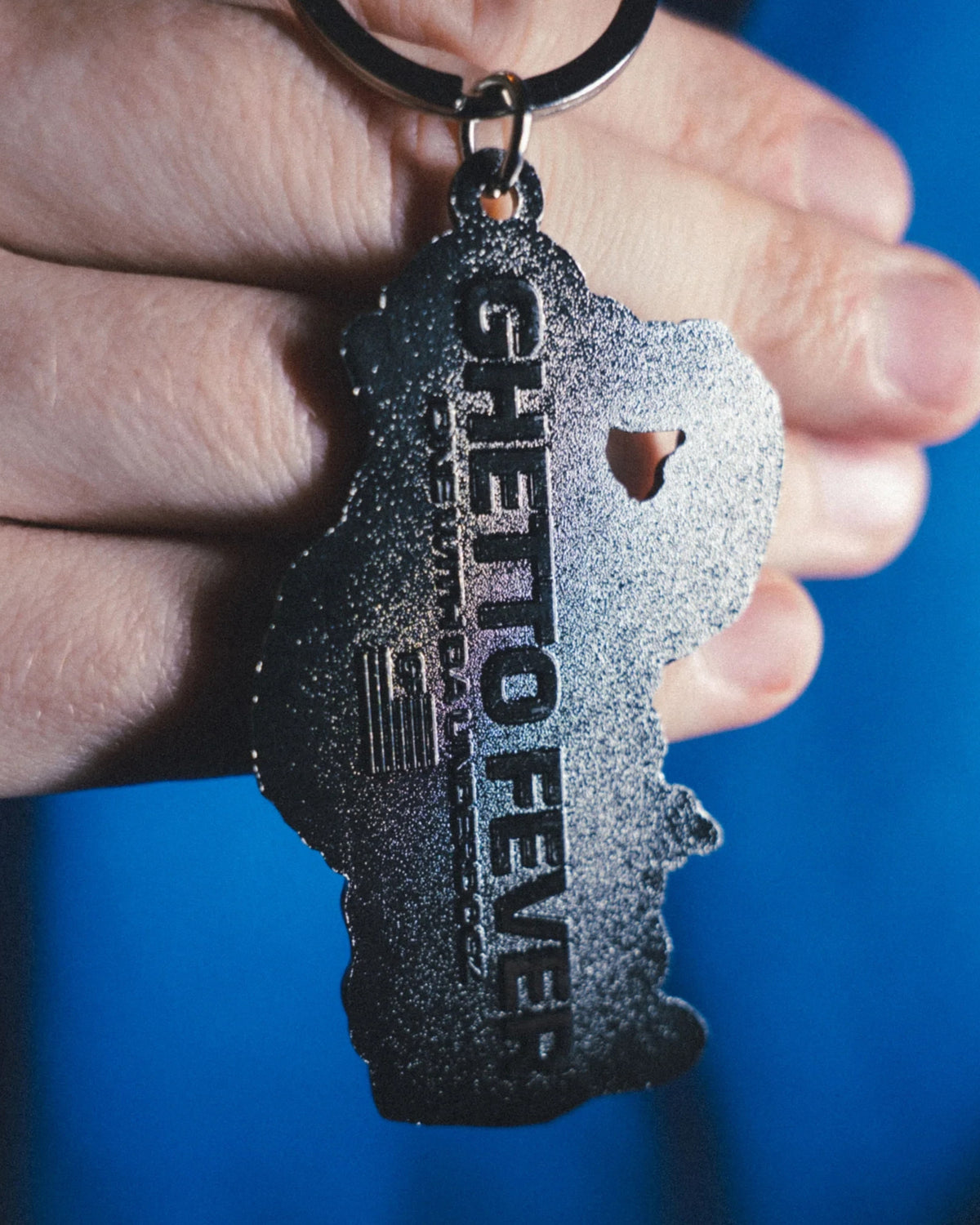 Astrofat Ghetto Fever Underdog rubber keychain with a metal ring held in a hand
