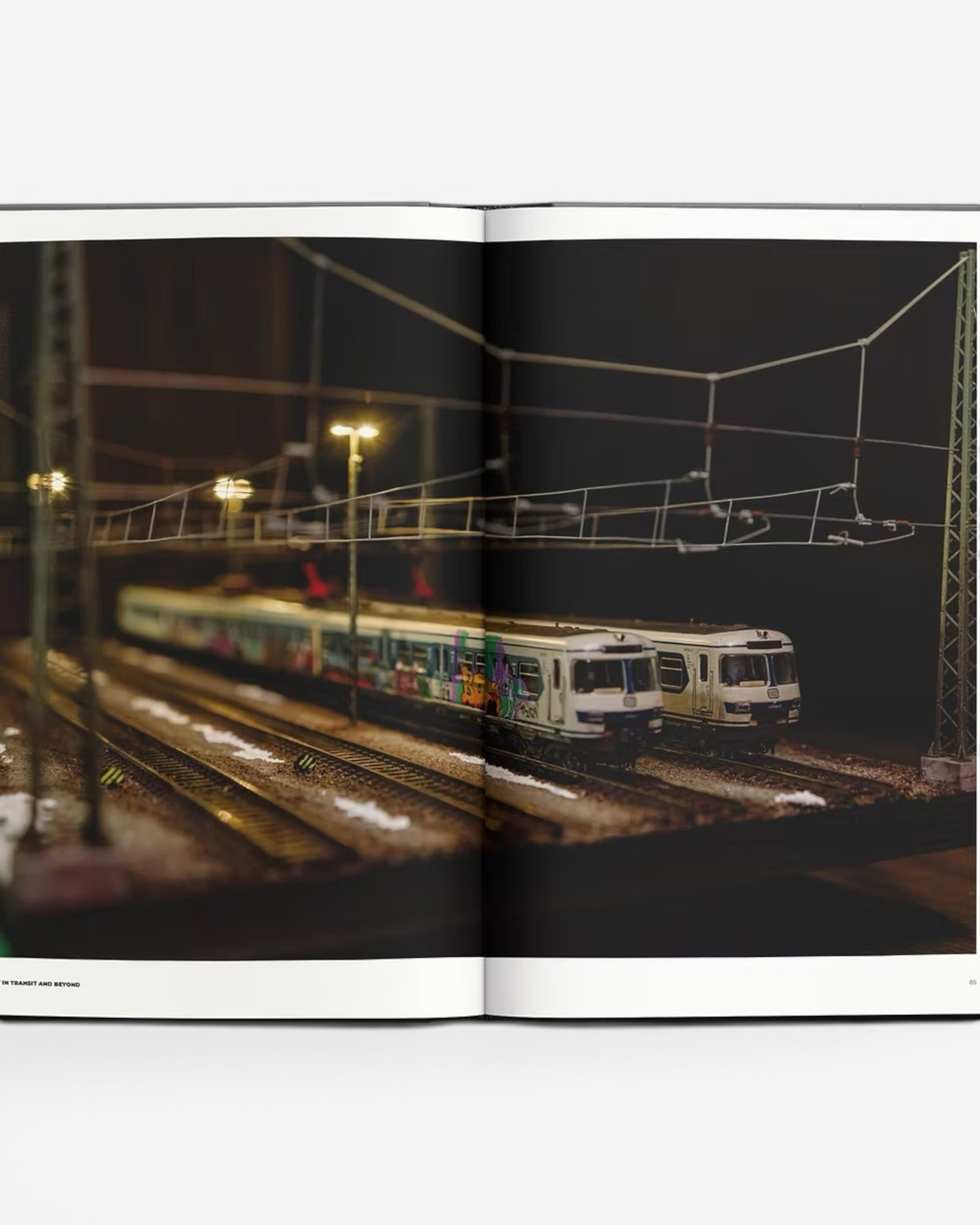 Astrofat Art In Transit And Beyond Hallenkunst book features model trains with graffiti art on tracks at night.