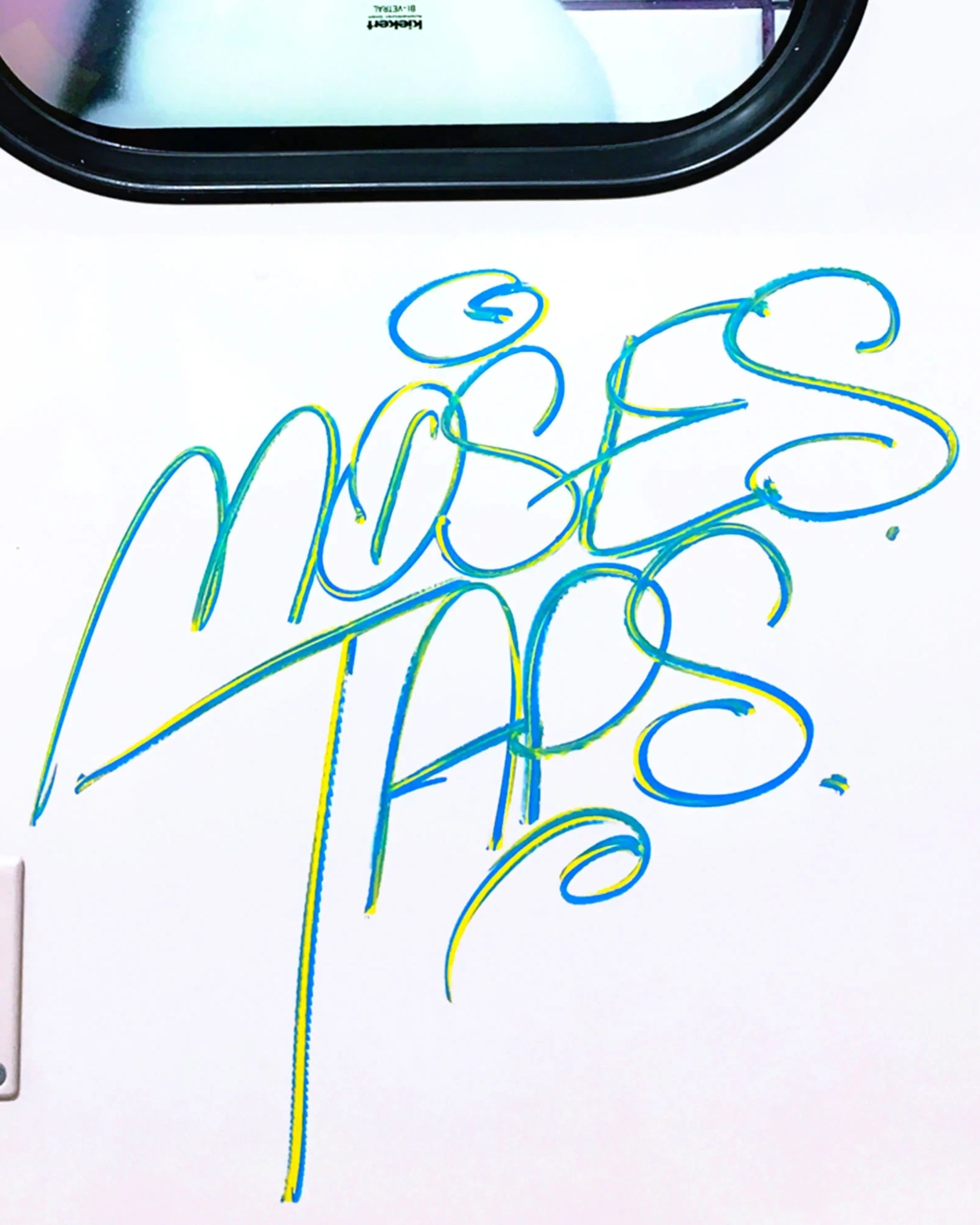 Astrofat HMX solid paint marker graffiti tag by MOSES & TAPS in blue and yellow on a white surface.