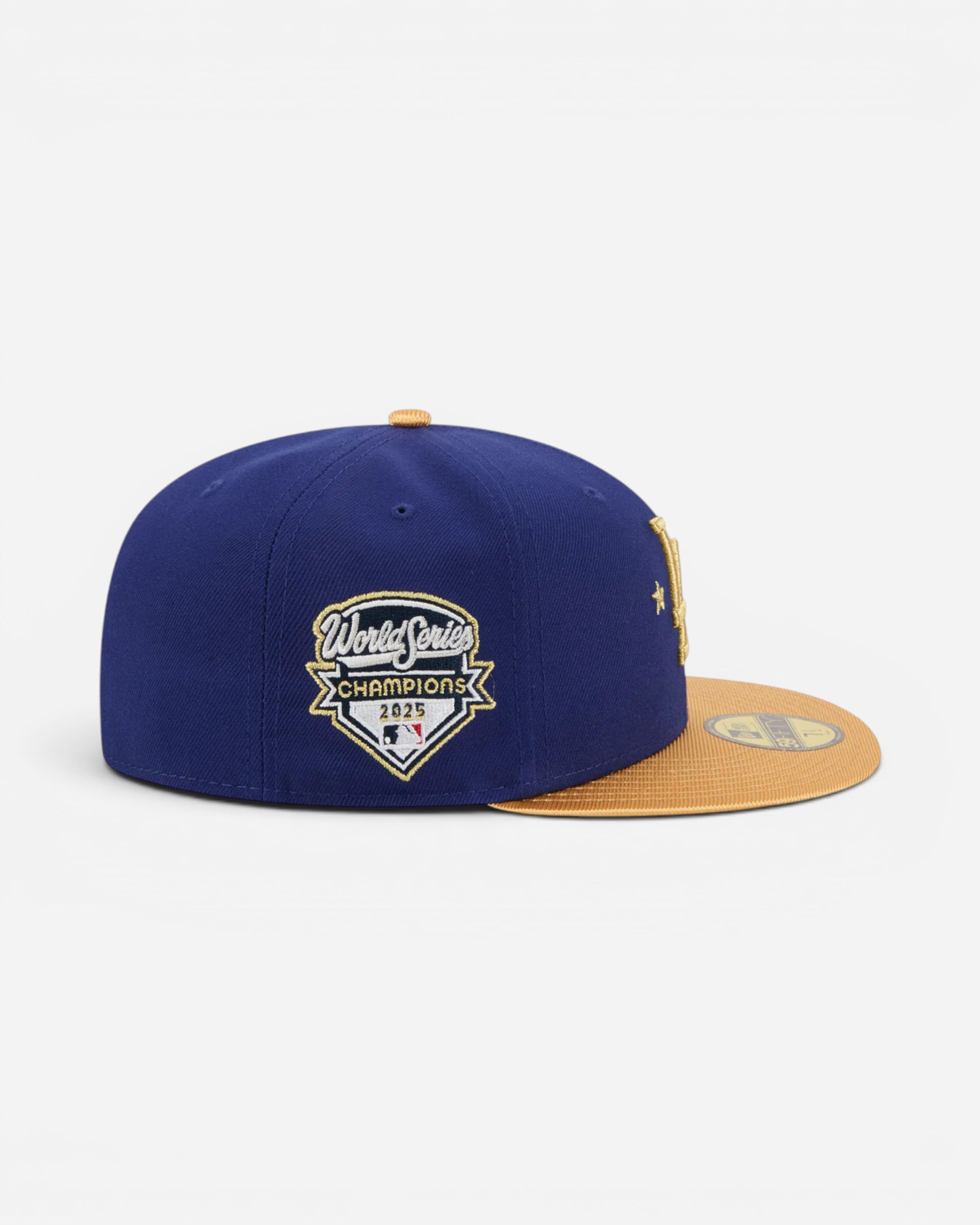 Astrofat dark blue fitted baseball cap with gold brim, featuring the 2025 World Series Champions patch for the LA Dodgers.