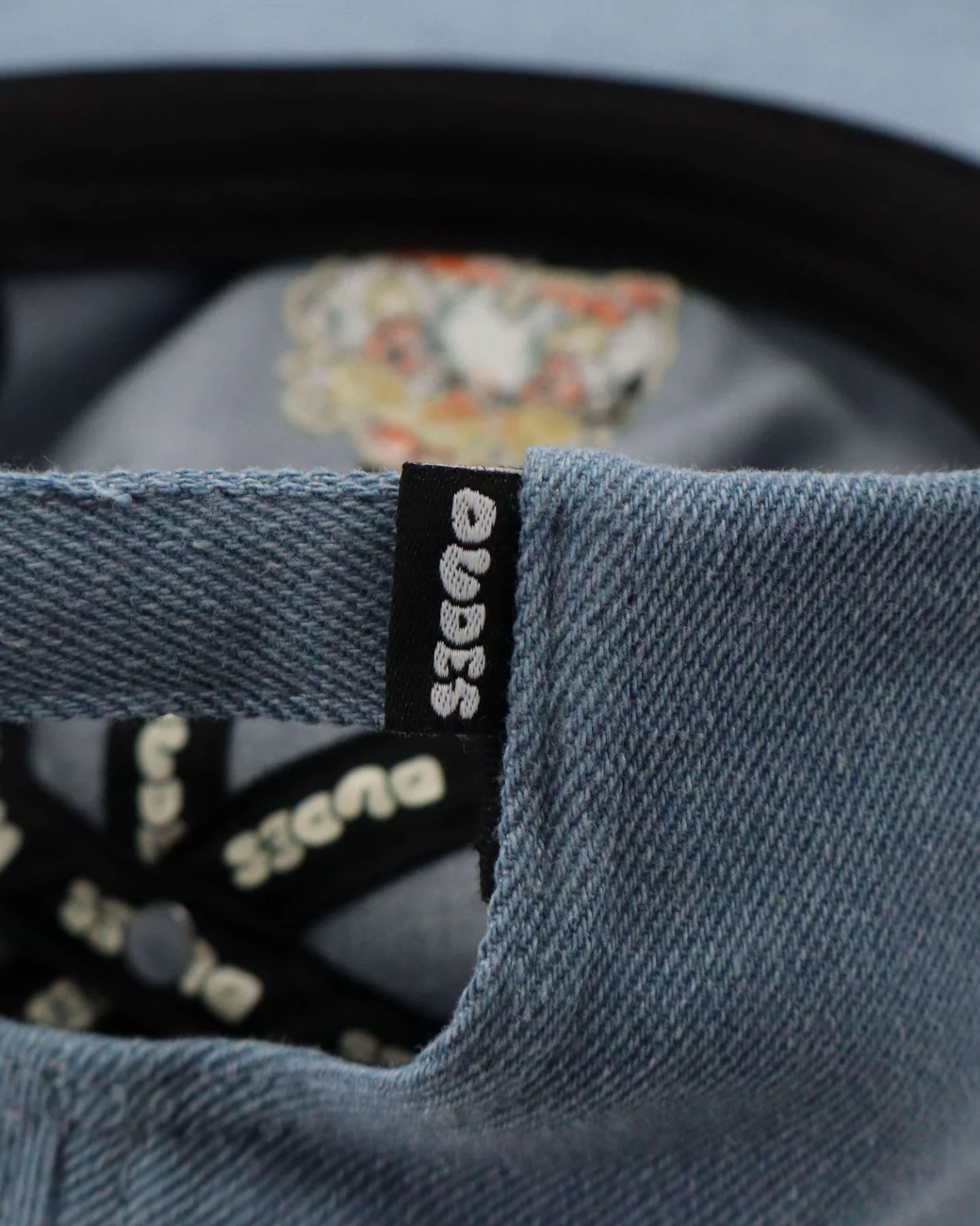 Astrofat light blue denim cap with black tag and embroidered graphic inside.