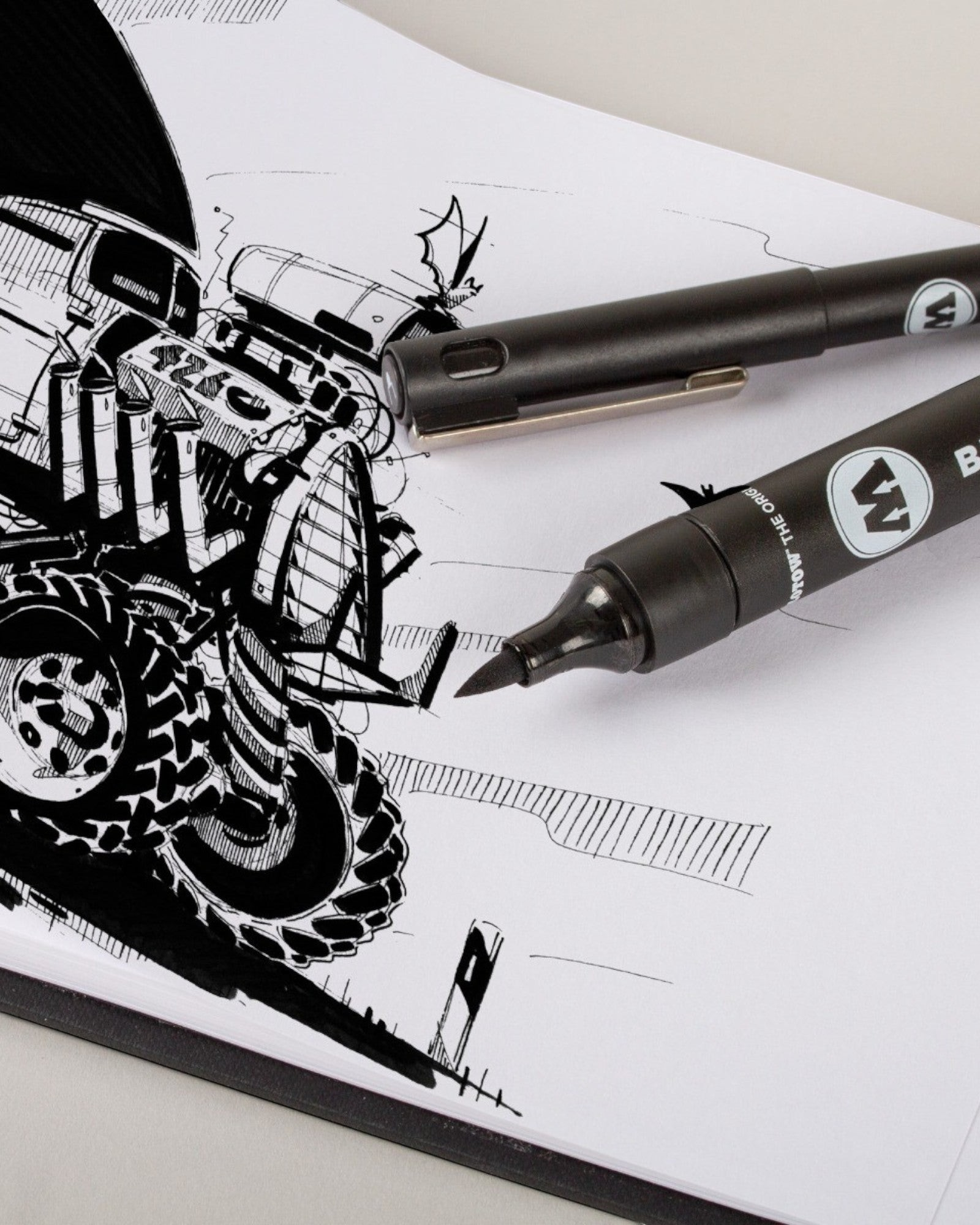 Astrofat Molotow A5 landscape blackbook with a detailed black ink tractor sketch and two black markers on white paper