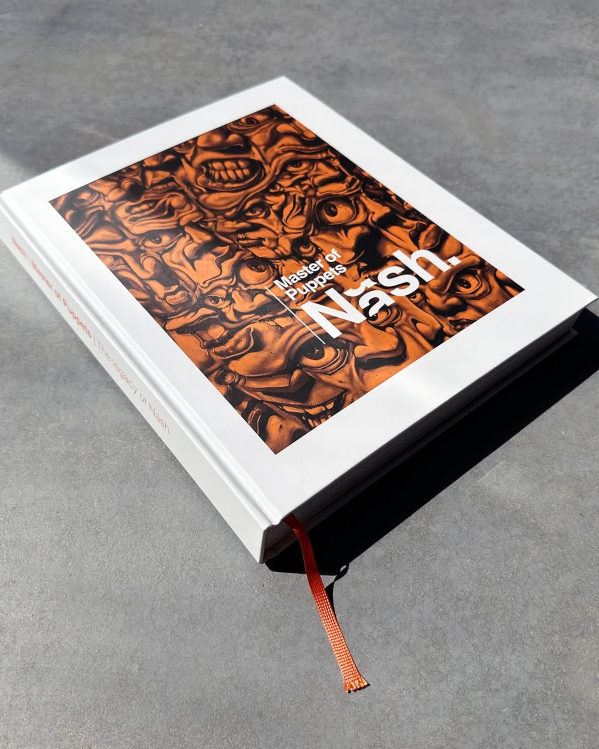 Astrofat Nash Master of Puppets art book with a white cover and orange illustrated detail on a grey surface.