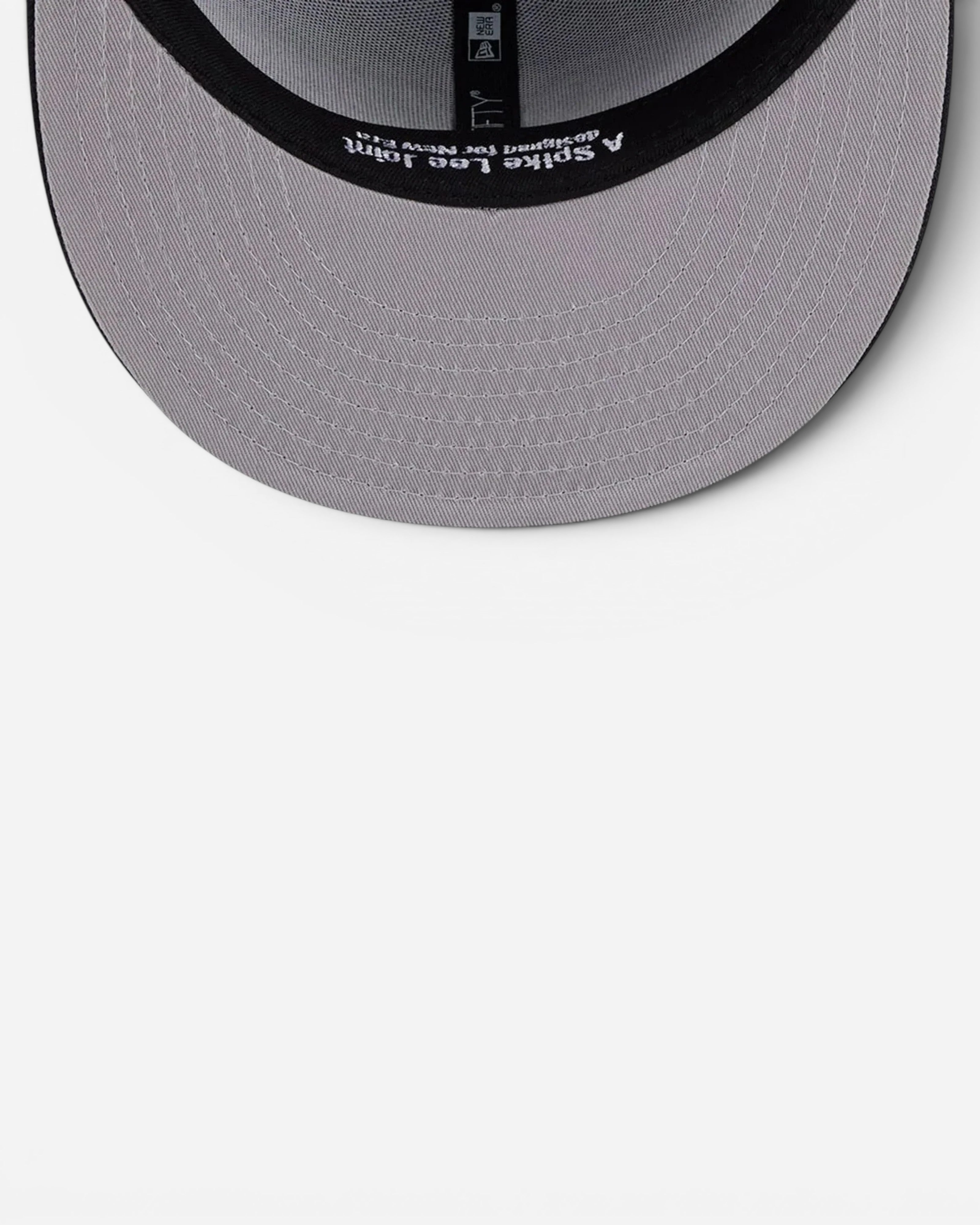 Astrofat New Era 59FIFTY fitted cap interior showing the grey undervisor and Spike Lee branding on the sweatband.