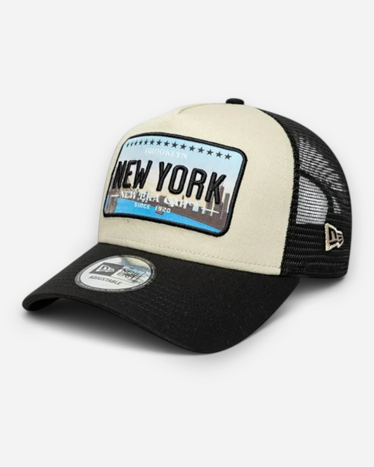 Astrofat 9FORTY New York trucker cap in cream and black with a curved visor, mesh back, and embroidered city patch.
