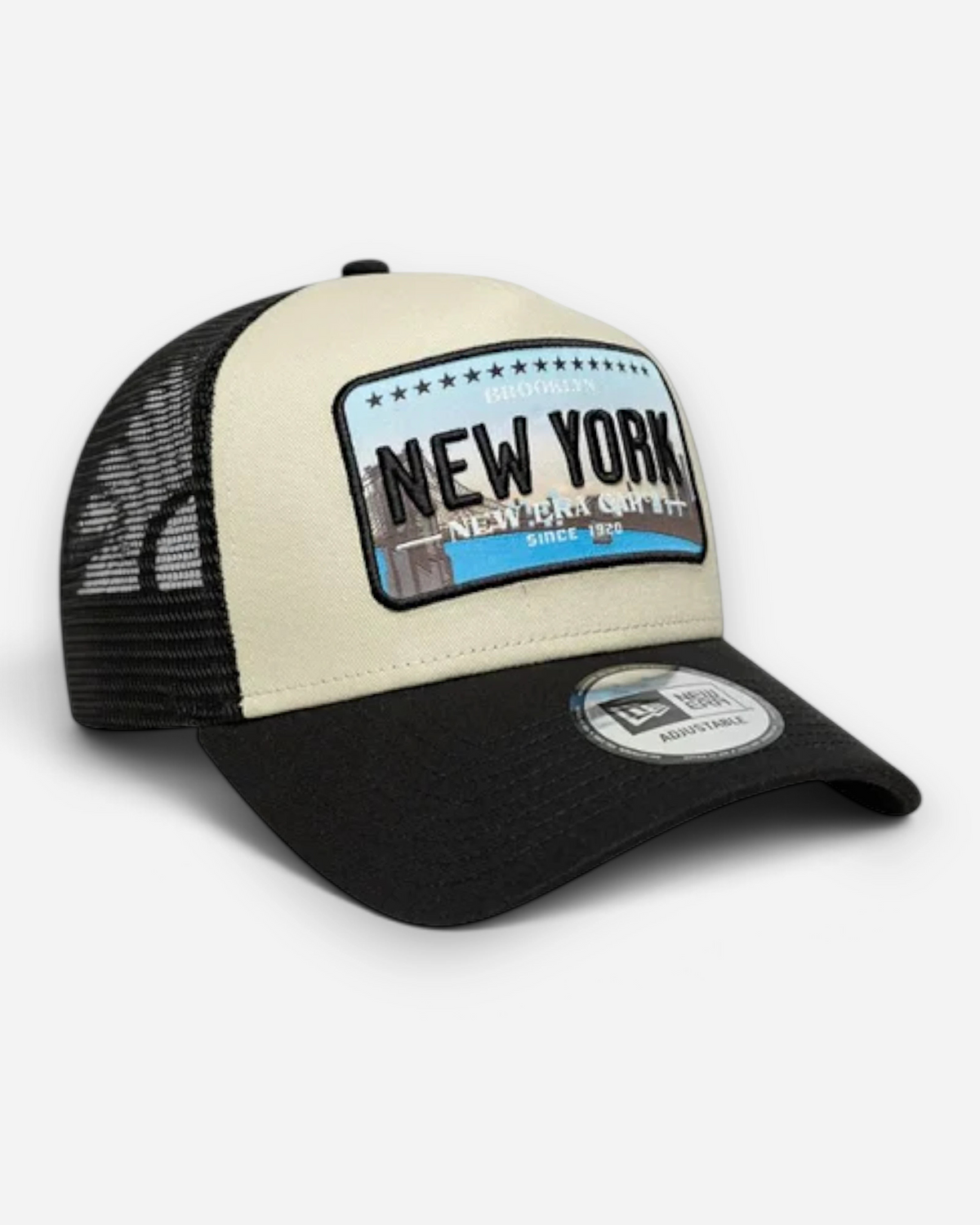Astrofat 9FORTY trucker cap in cream and black with a New York patch, curved visor, and breathable mesh back.