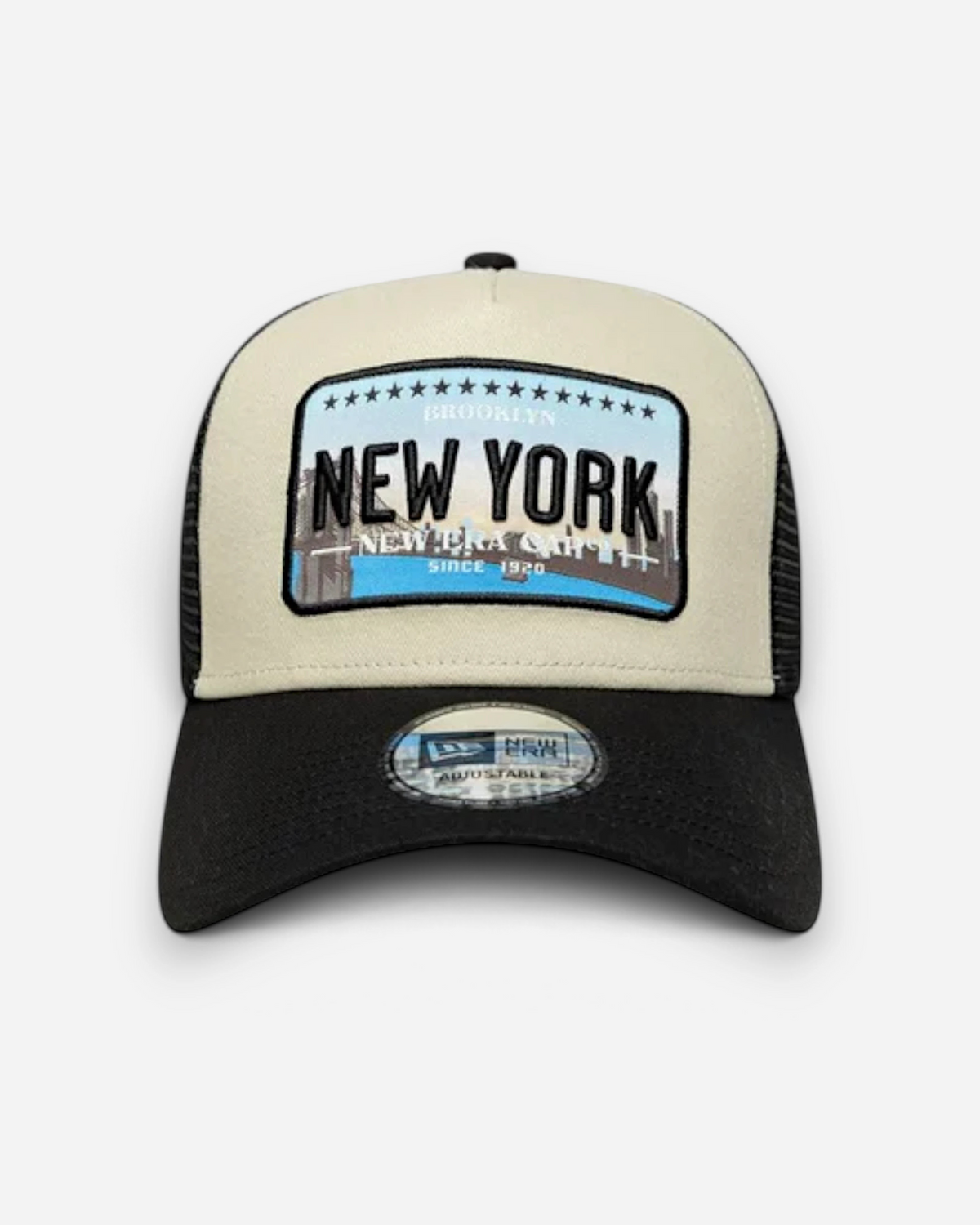 Astrofat 9FORTY trucker cap in cream and black with a New York graphic patch and curved visor.