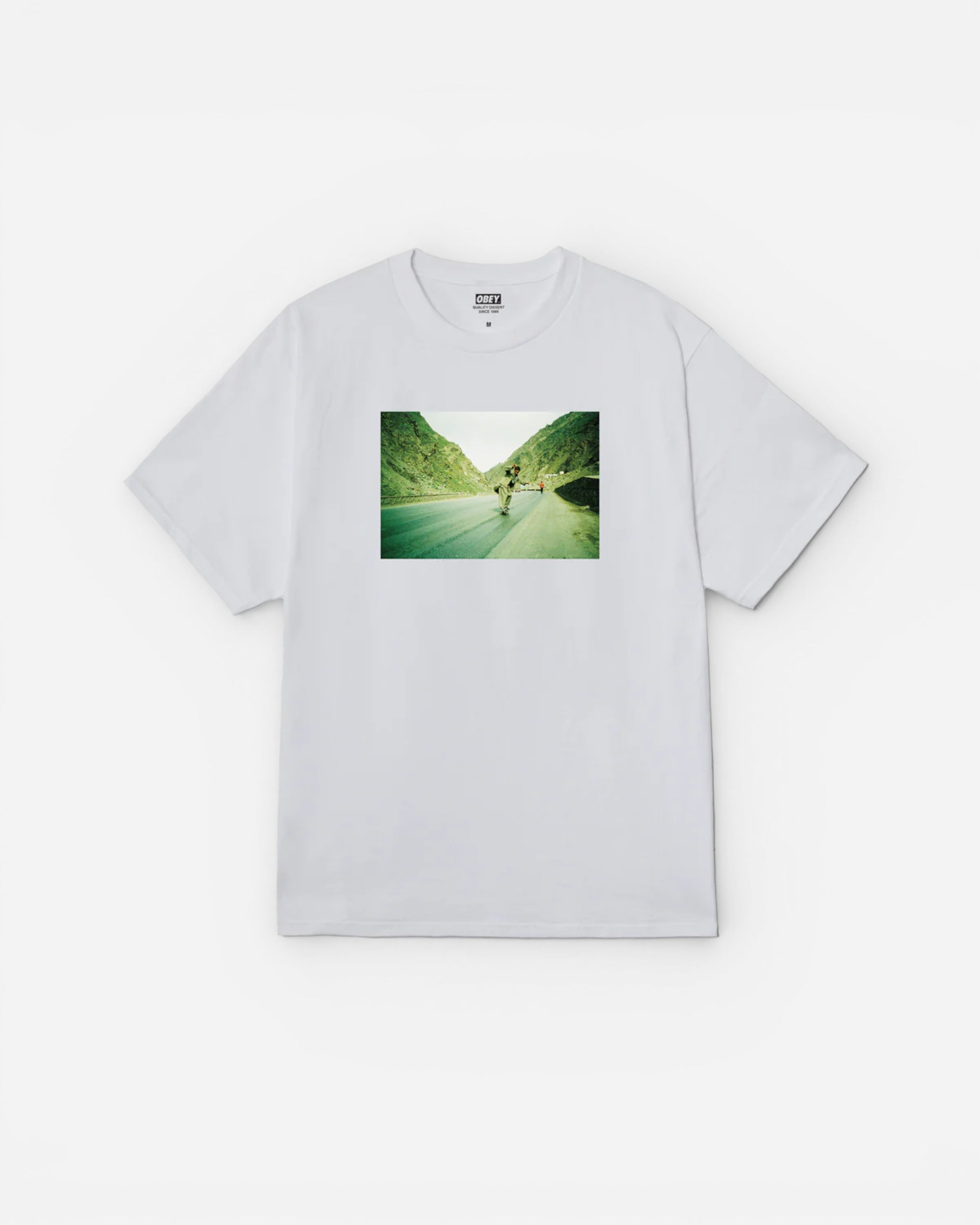Astrofat Skateistan Obey Photo Tee in white 100% cotton with a graphic print of a skateboarder on a mountain road.