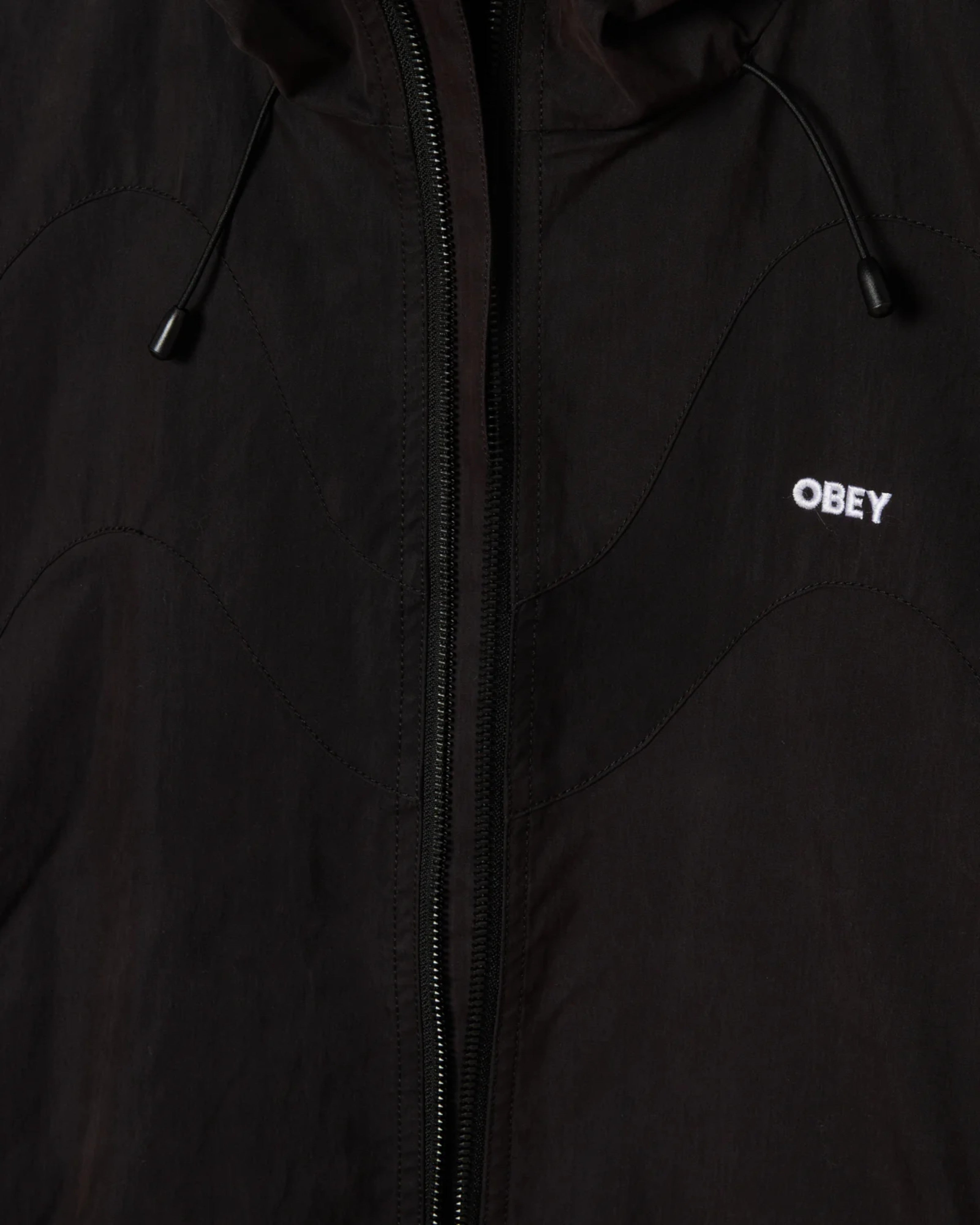 Astrofat Obey Sota Shell Jacket in black, featuring a zip closure, adjustable hood, and embroidered logo.