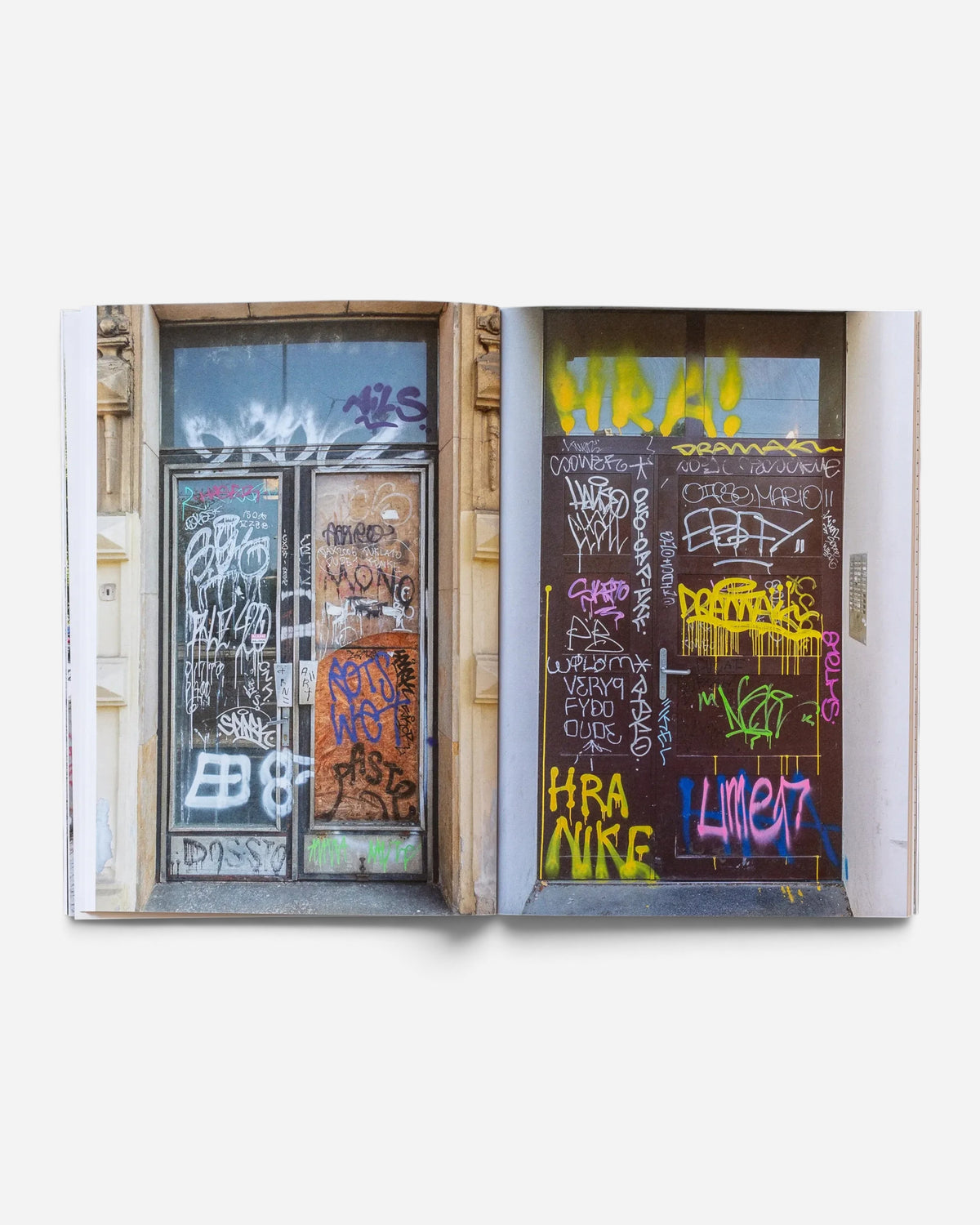 Astrofat Praha Tourist Information zine showing graffiti-covered doors in Prague with colorful tags and throw-ups.