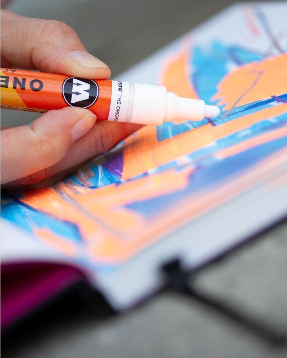 Astrofat A4 professional blackbook being used with an orange acrylic paint marker for sketching on white paper