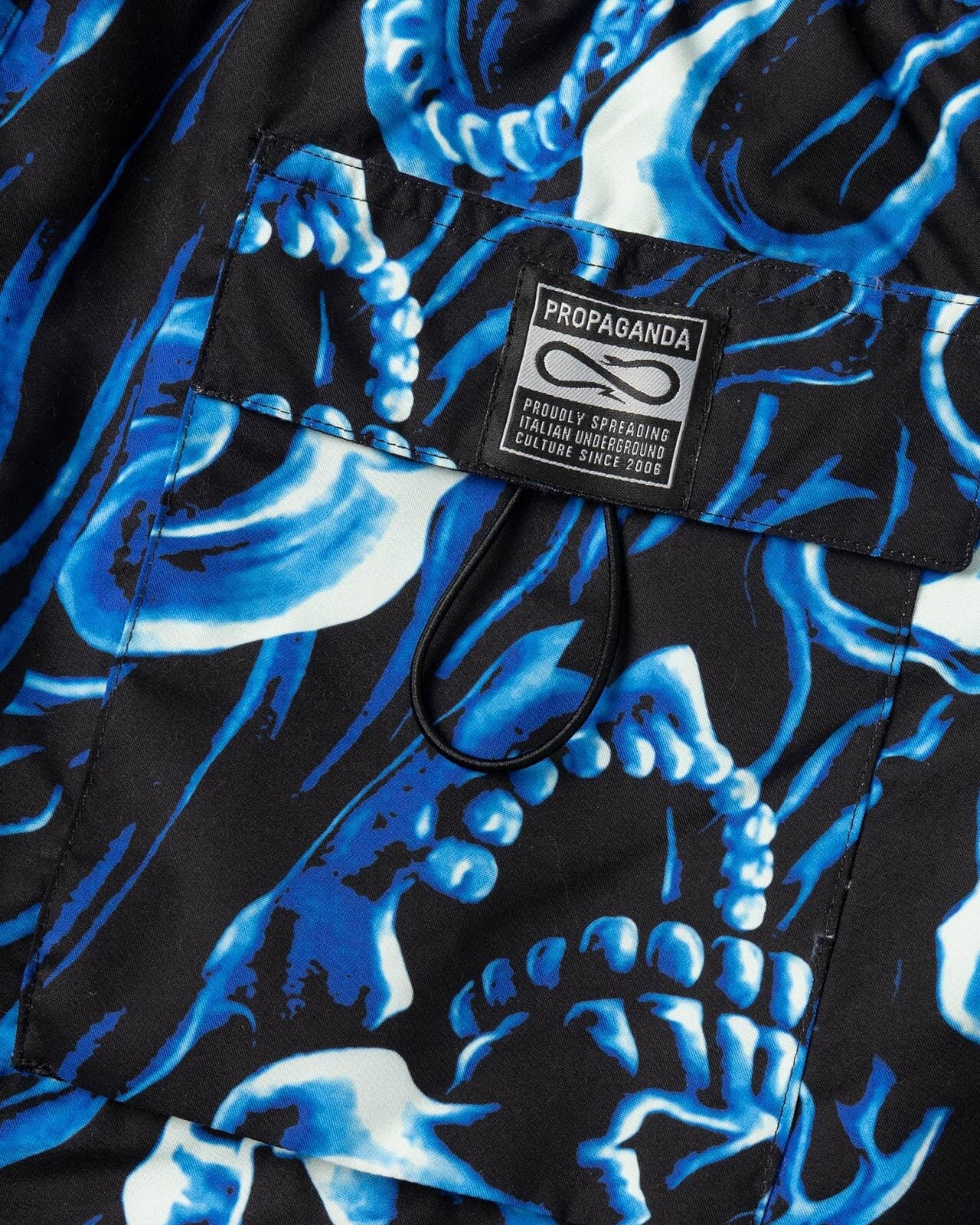 Astrofat Propaganda Ghostrider swim trunks in blue with an all-over skull print and a back pocket with a woven label.