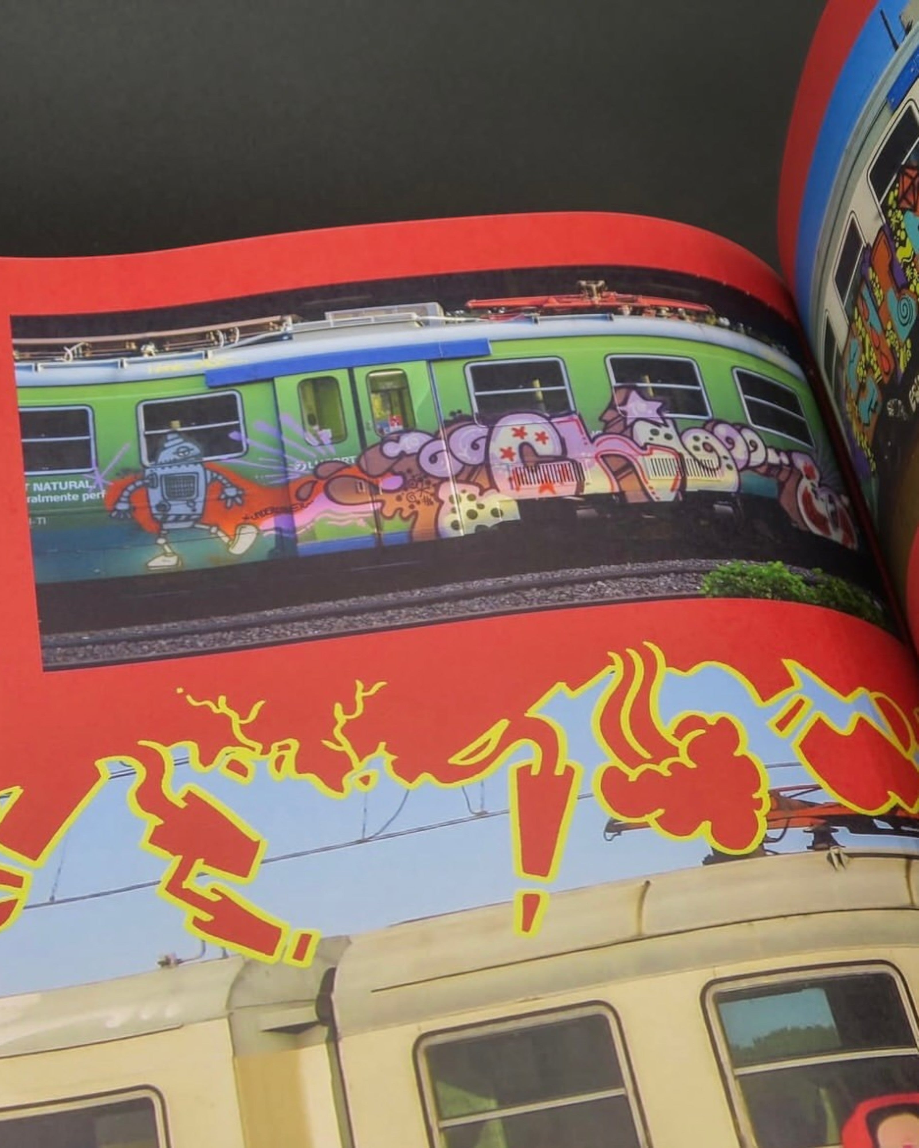 Astrofat Reincarnations book page showing vibrant graffiti art on trains with cartoon characters and bold red accents.