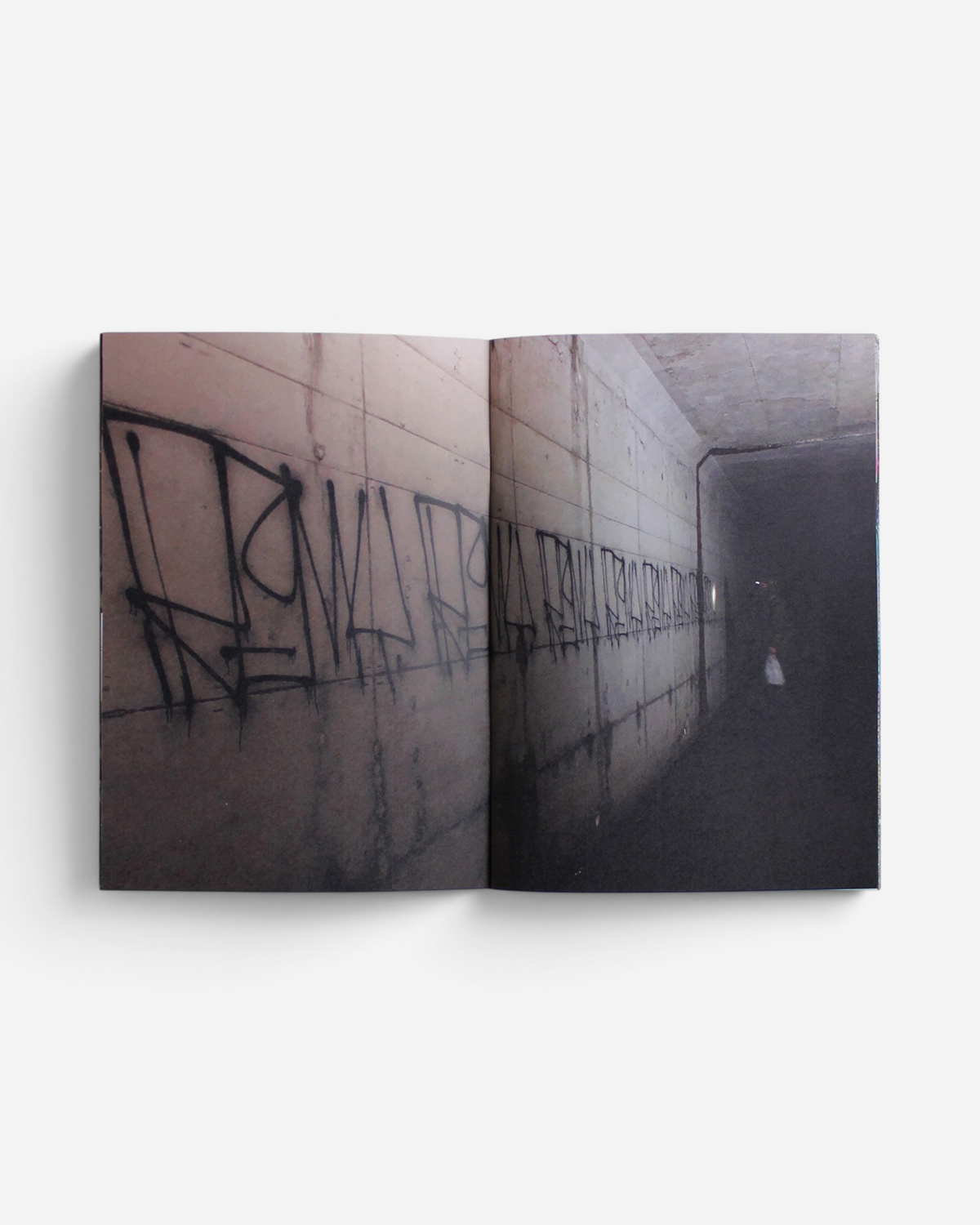 Astrofat Remio Very Top Secret zine open to a page showing black graffiti tags on a concrete tunnel wall.