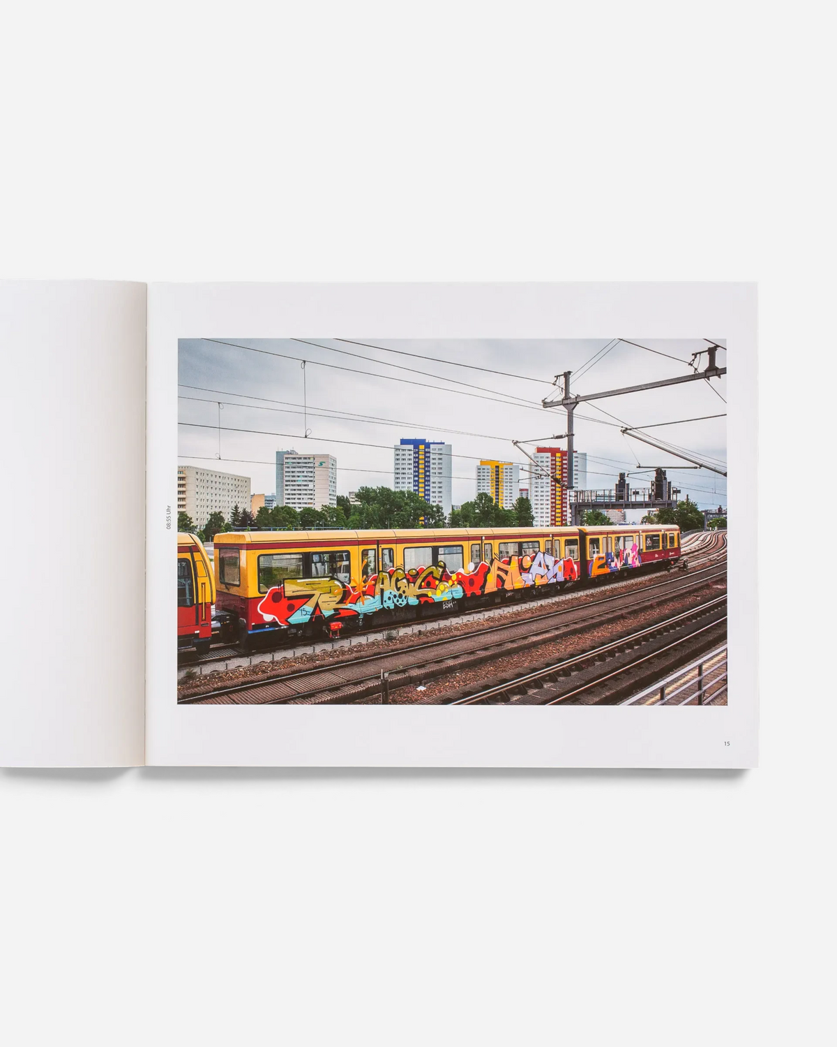 Astrofat Schriftzüge photography book open to a page showing a yellow Berlin S-Bahn train covered in vibrant graffiti