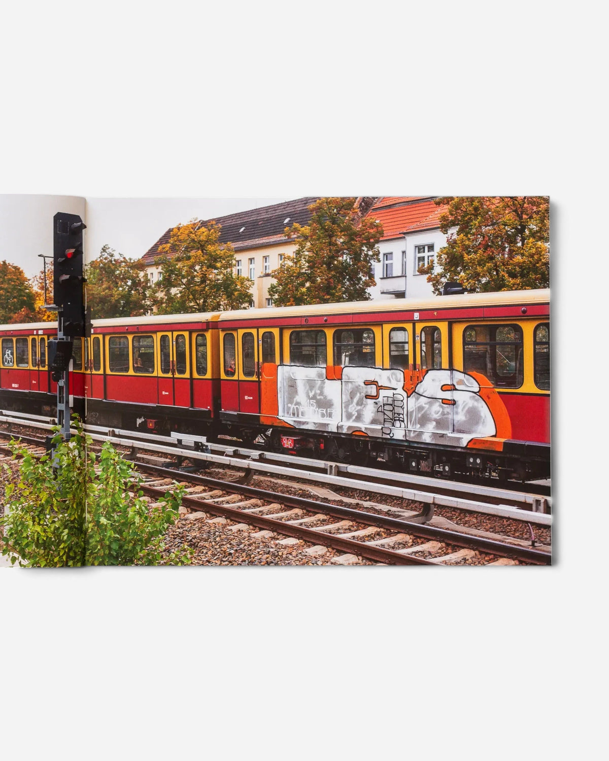 Astrofat Schriftzüge photo book open to a page showing a red and yellow Berlin S-Bahn train with graffiti art