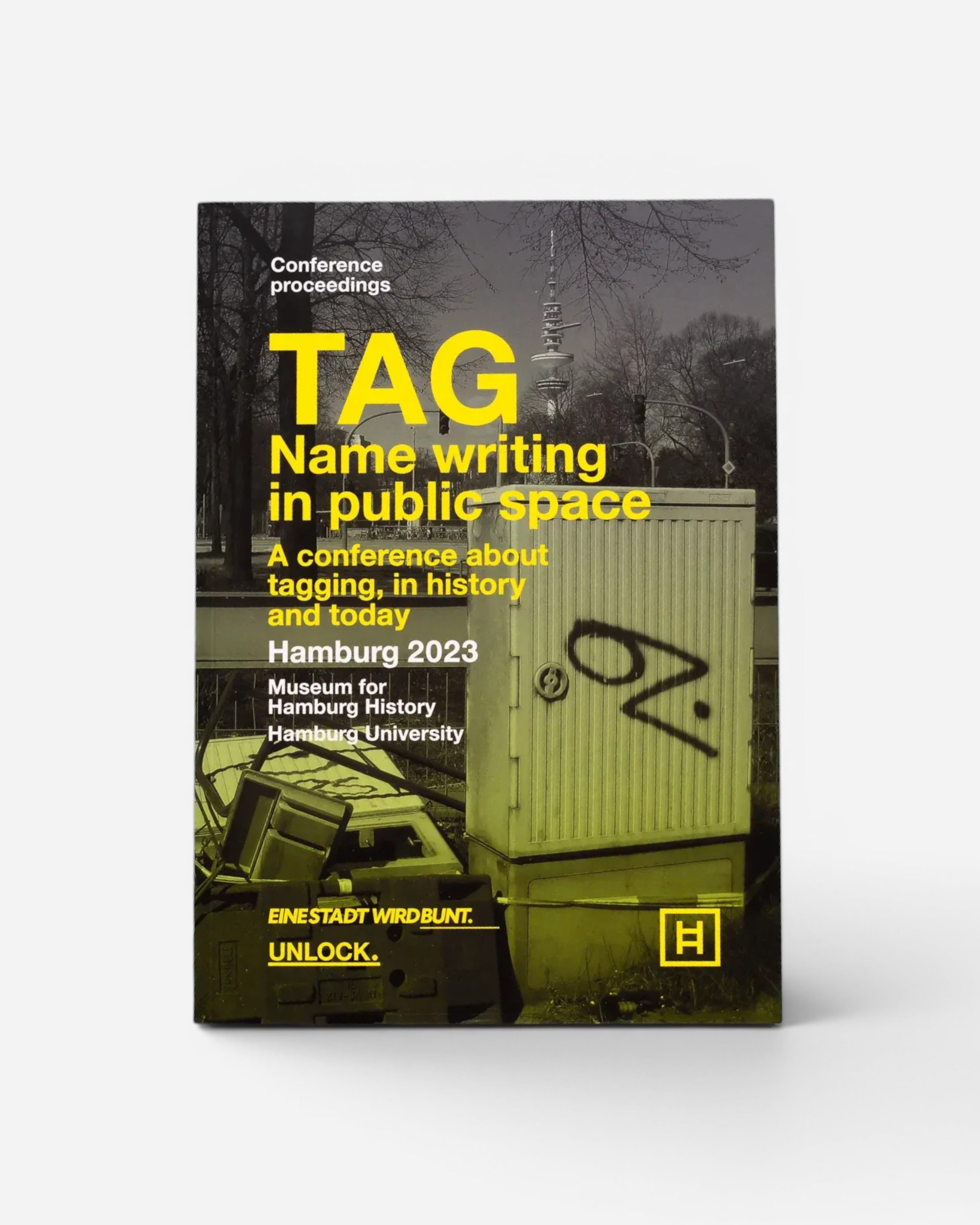Astrofat TAG Name writing in public space book cover featuring yellow typography on a black and white Hamburg street scene