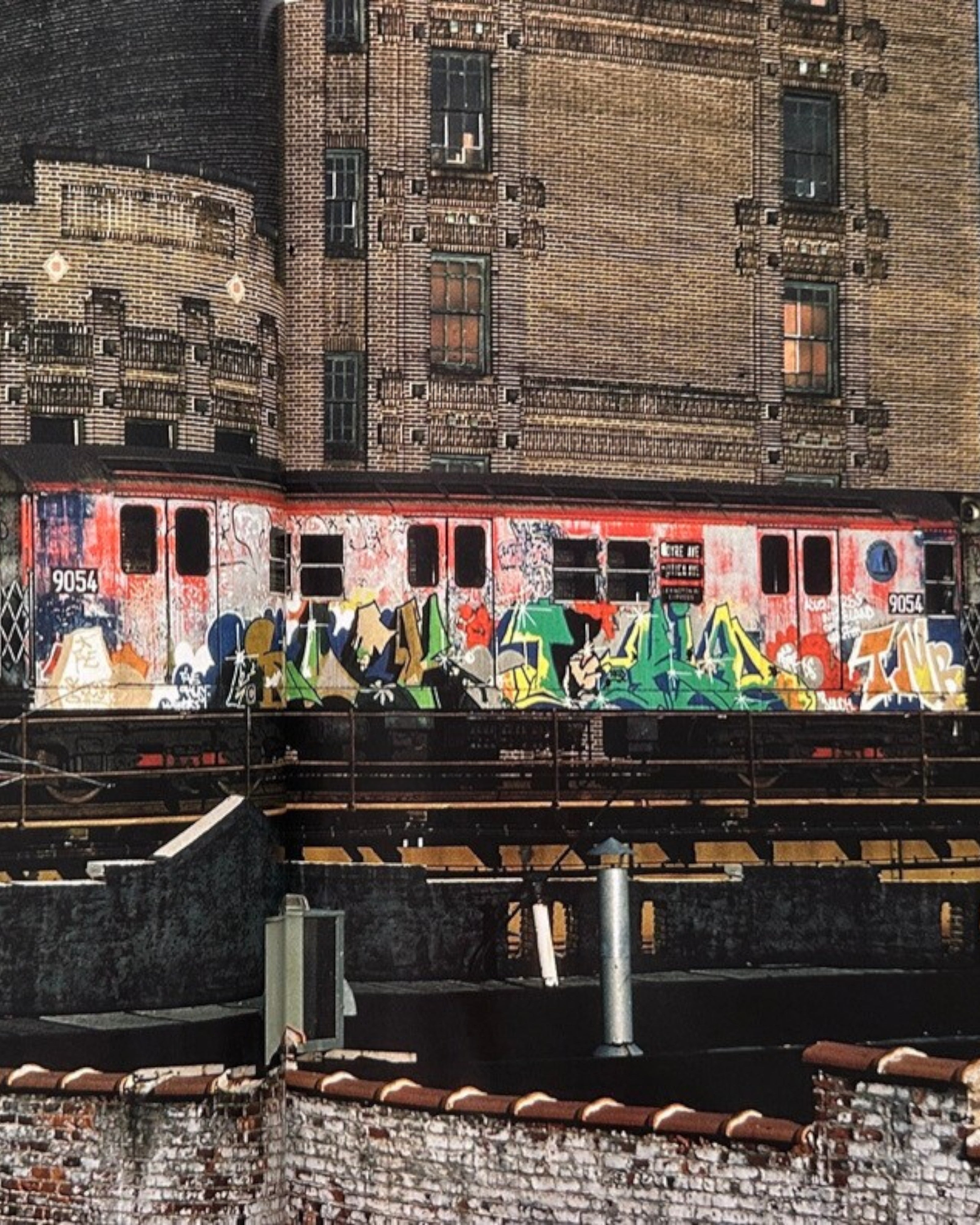 Astrofat book cover featuring a New York subway train covered in colorful graffiti, with brick buildings in the background.