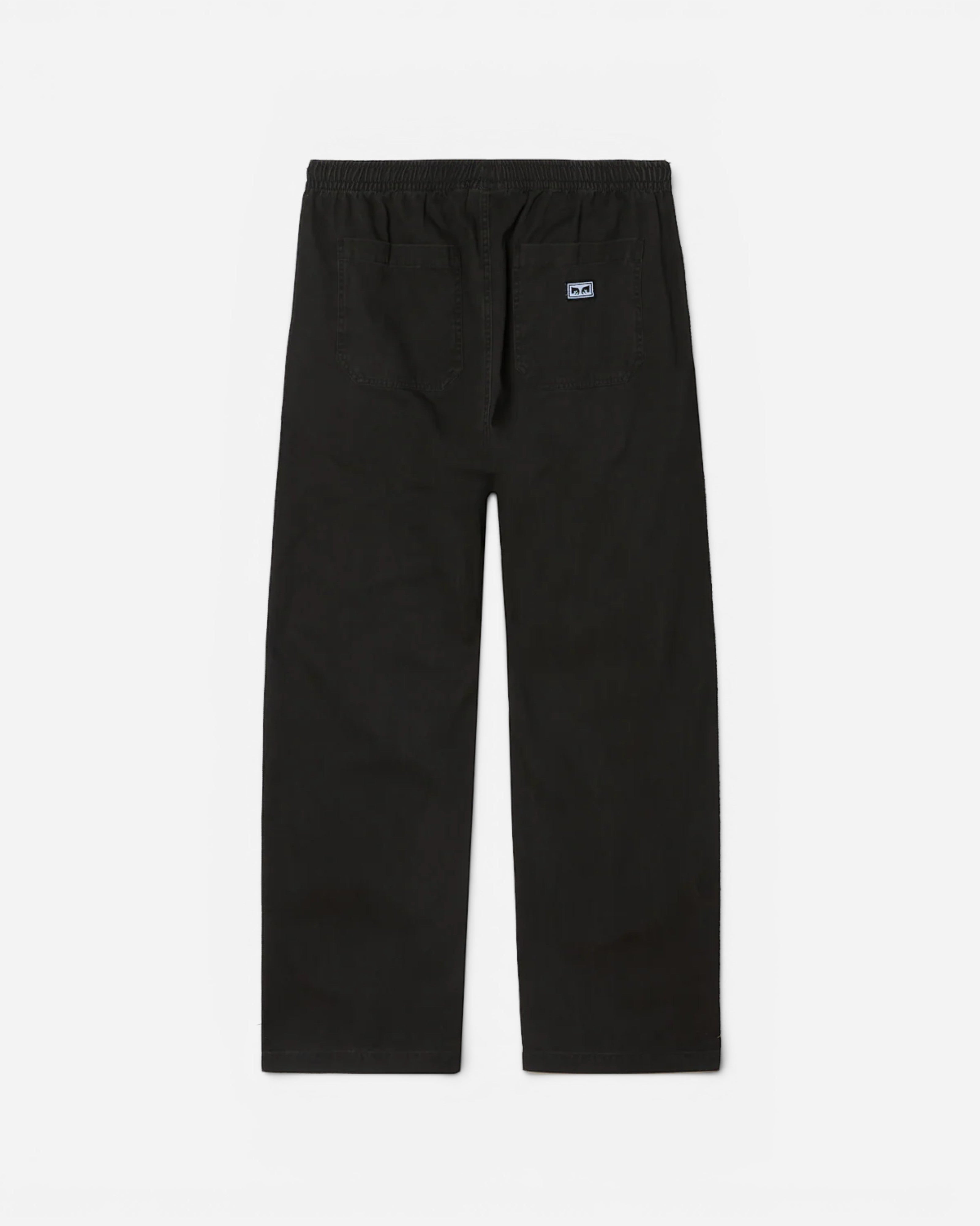 Astrofat Theo Easy Pants in black faded wash cotton. Features elastic waistband, drawstring, front and back pockets, and Obey label.