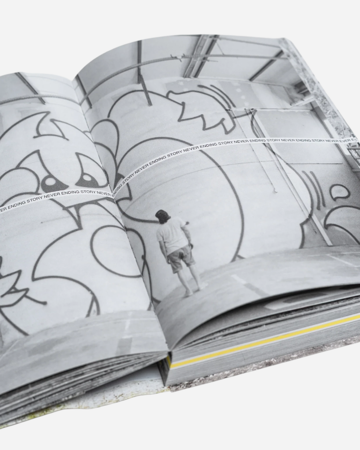 Astrofat Tilt Never Ending Story graffiti book open to a page showing a black and white photo of a street artist