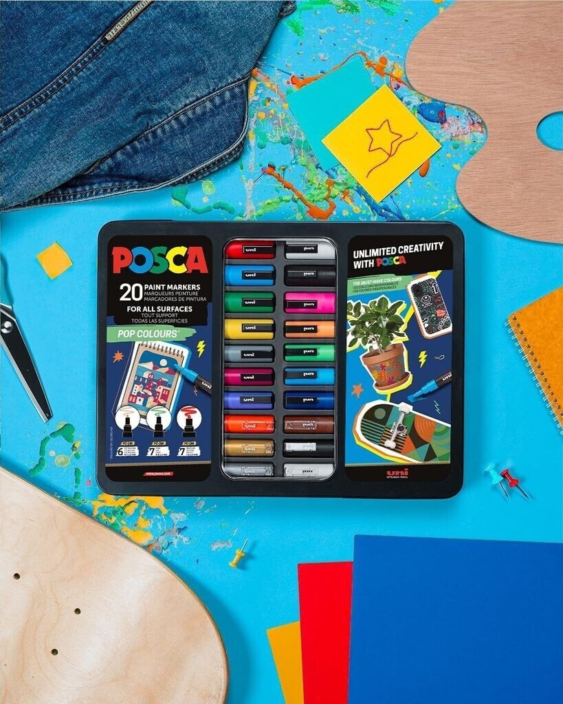 Astrofat Uni Posca paint marker set of 20 in a black display case on a blue desk with art supplies and denim.