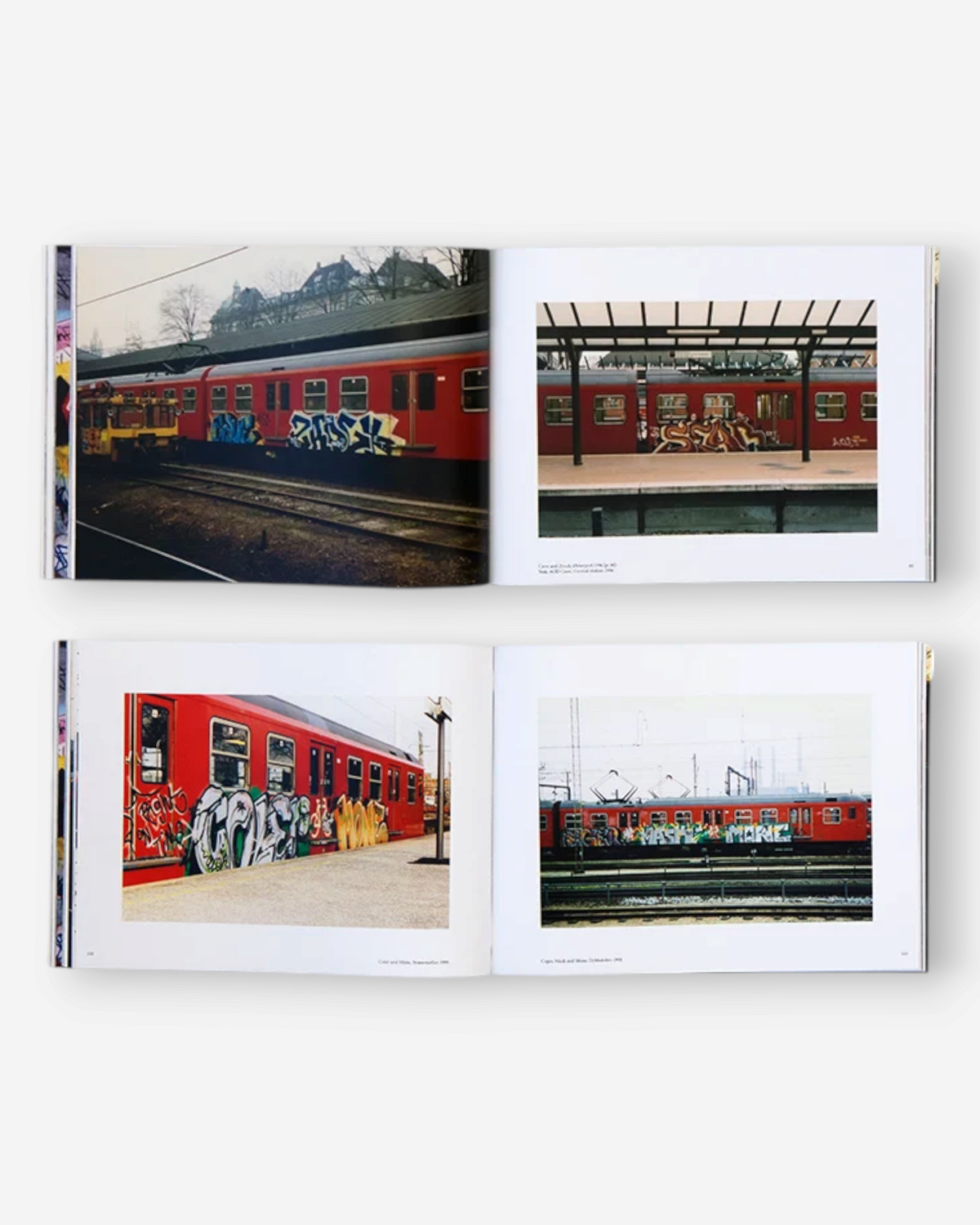 Astrofat Copenhagen Graffiti 1985-2016 book open to pages showing red trains with colorful graffiti in Denmark.